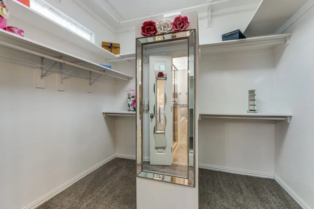 2nd floor primary walk in closet with carpet