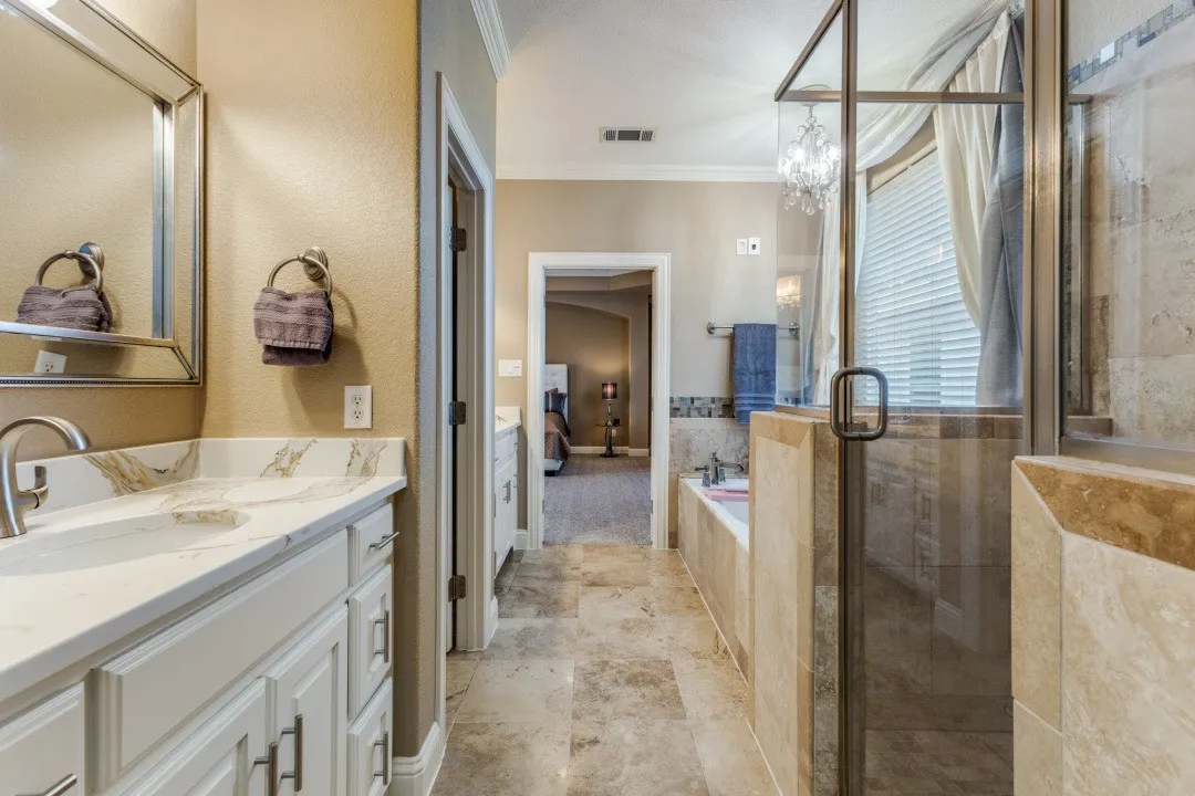 2nd floor primary
bathroom with a shower stall, a jetted tub, ornamental molding, and stone finish floors