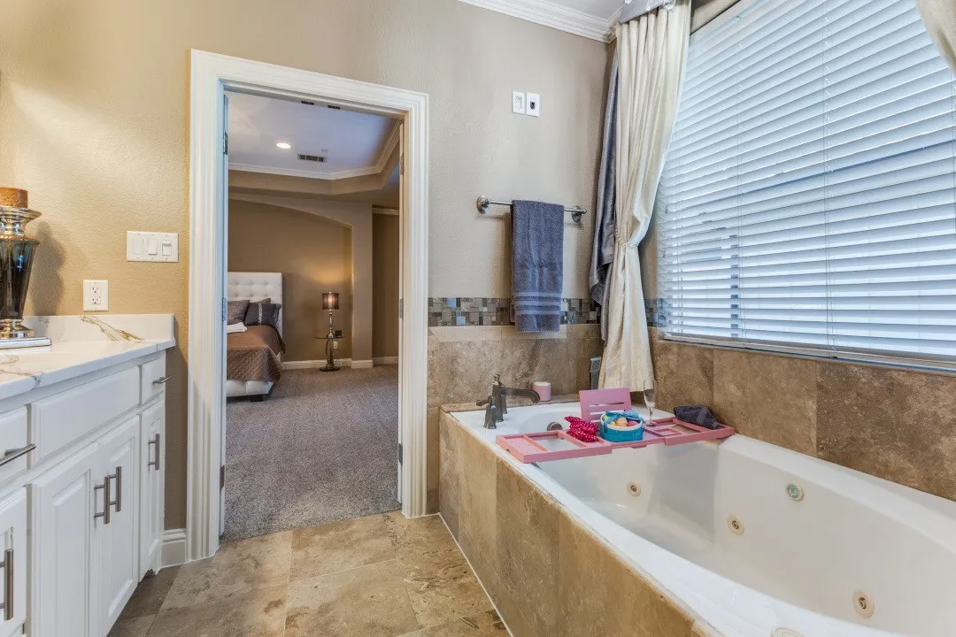2nd floor primary
bathroom with a shower stall, a jetted tub, ornamental molding, and stone finish floors