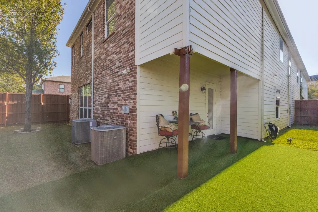 Rear view of house featuring a fenced backyard and brick siding