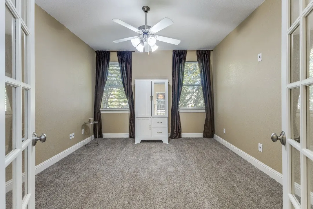 Spare room with light carpet and a ceiling fan