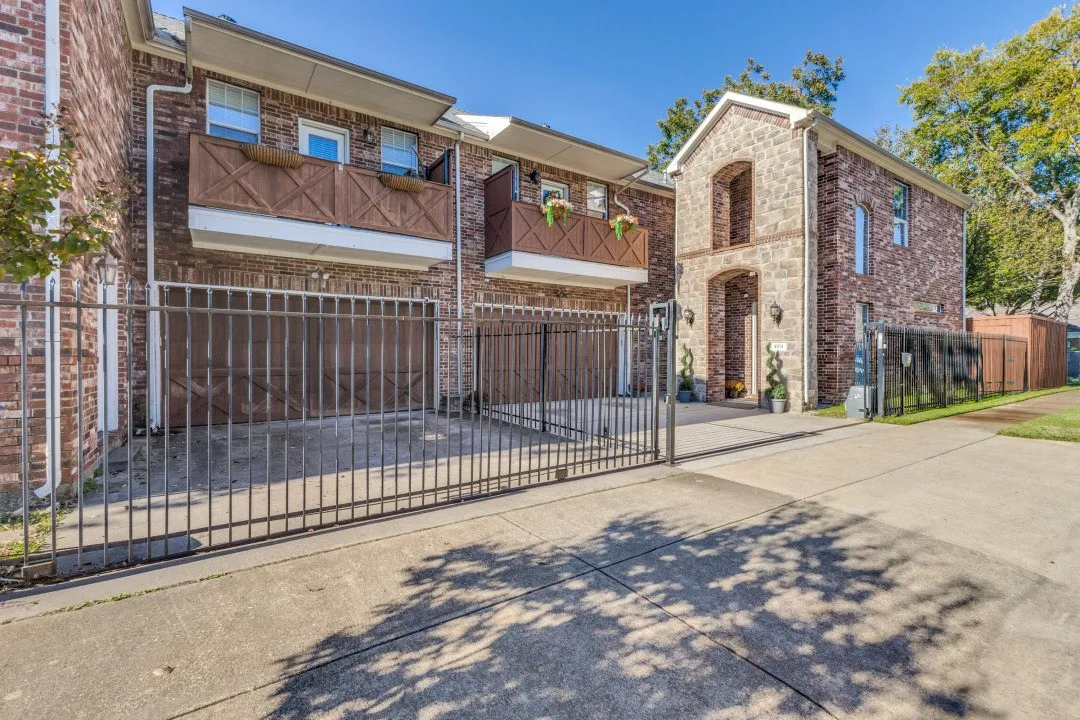 View of front of property with a fenced front yard, concrete driveway, and a gate