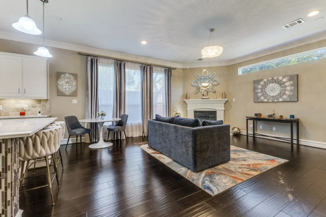 Living area with a fireplace, crown molding, and dark wood-style floors