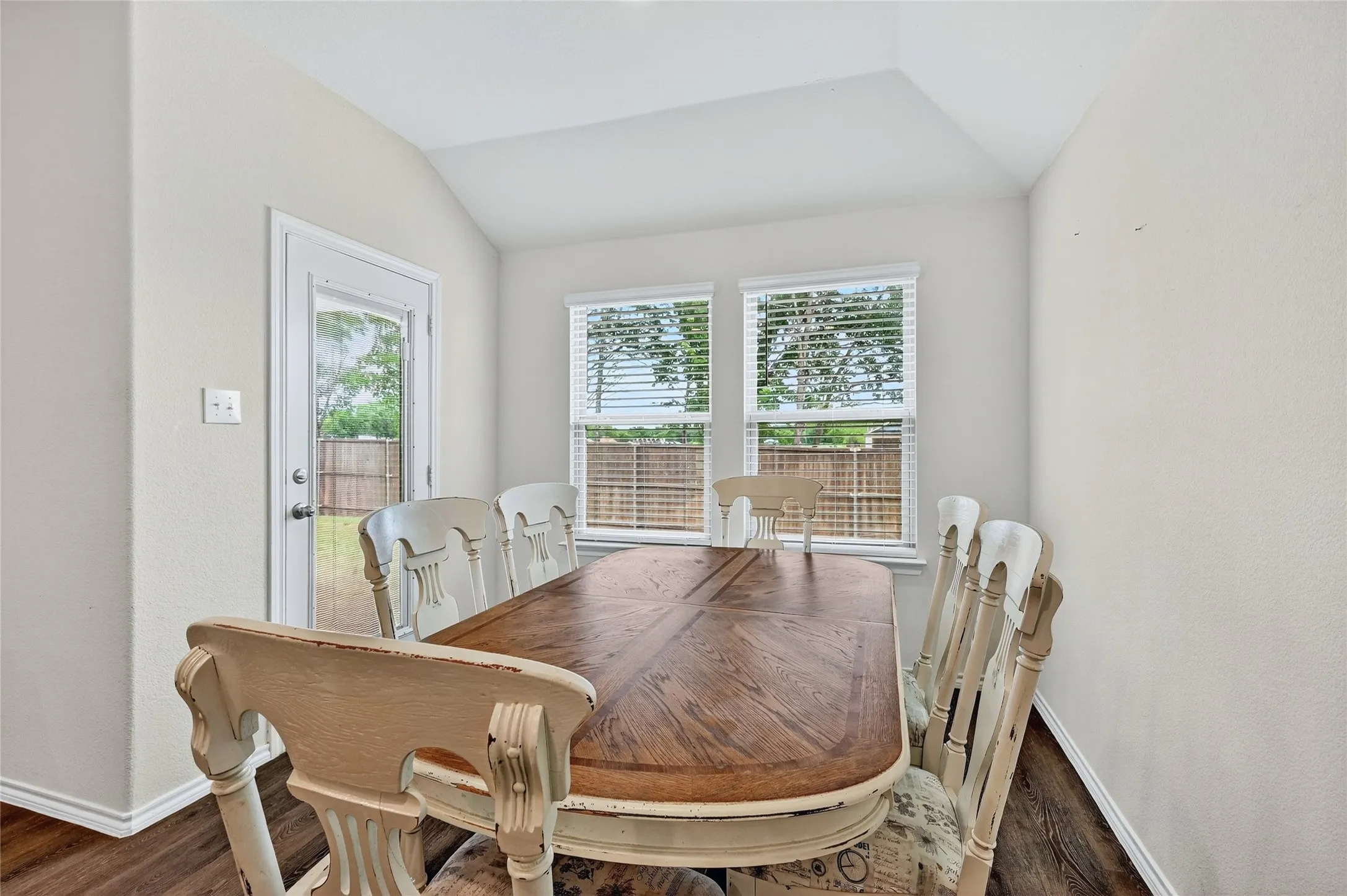 Dining area featuring vaulted ceiling and wood finished floors