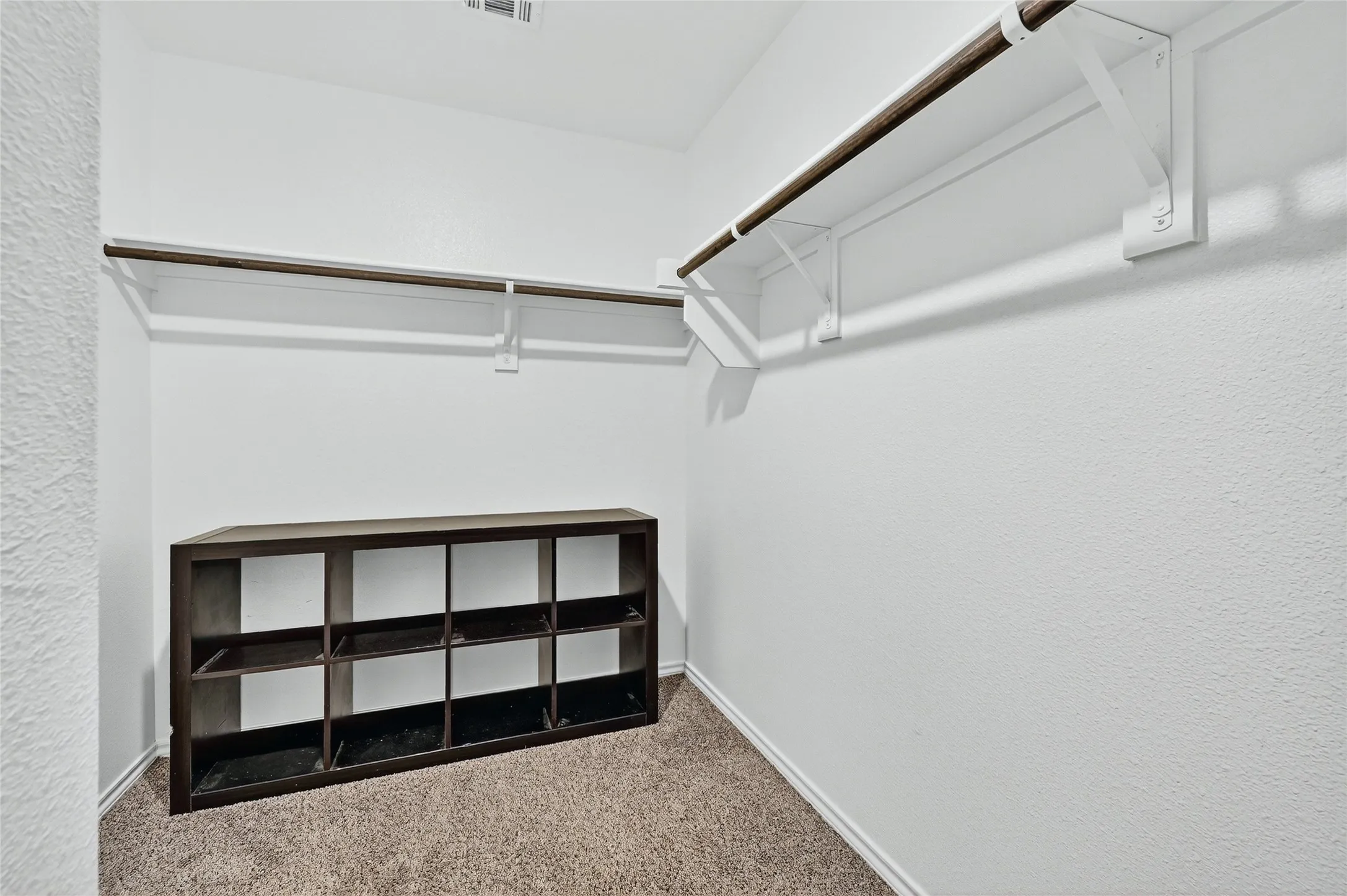 Walk in closet with carpet floors