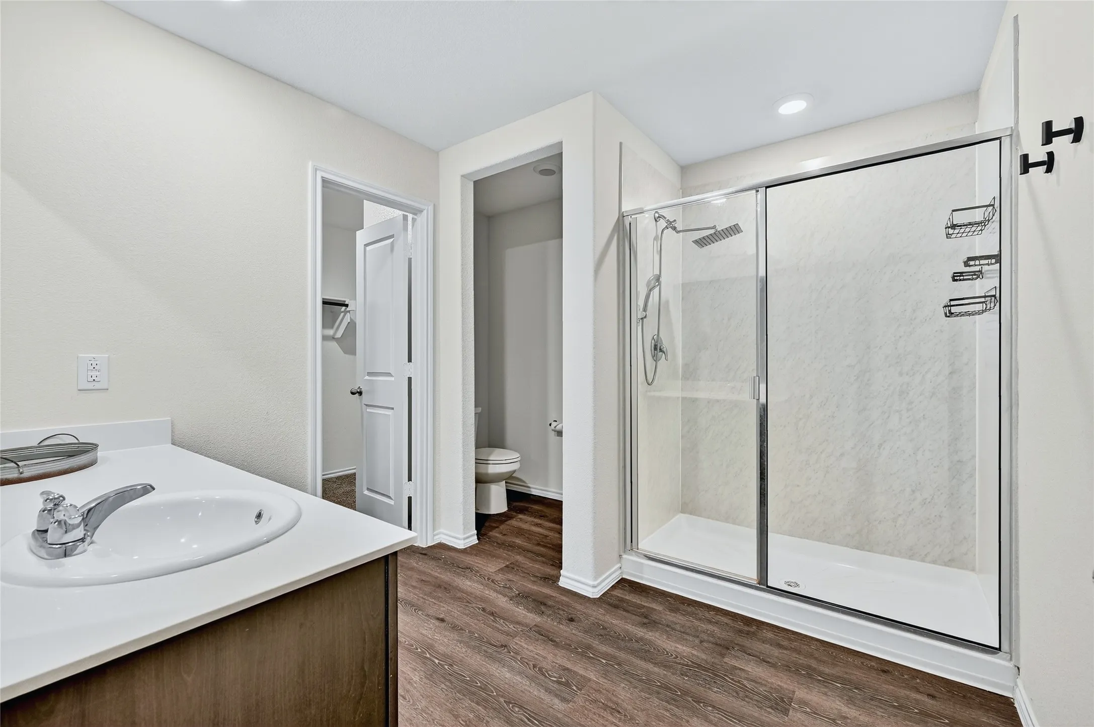 Full bath with a stall shower, wood finished floors, and vanity