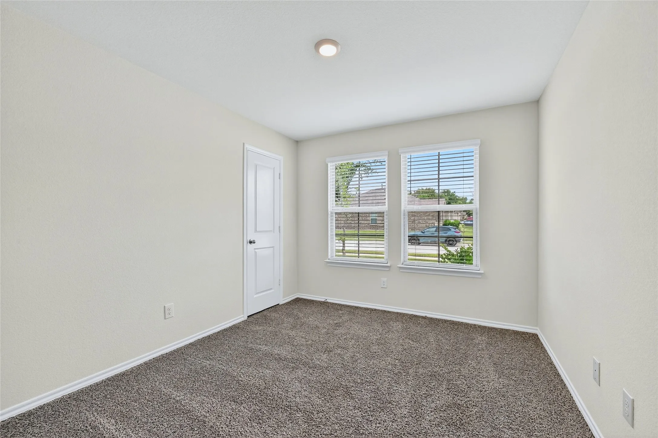 Spare room featuring carpet flooring and baseboards