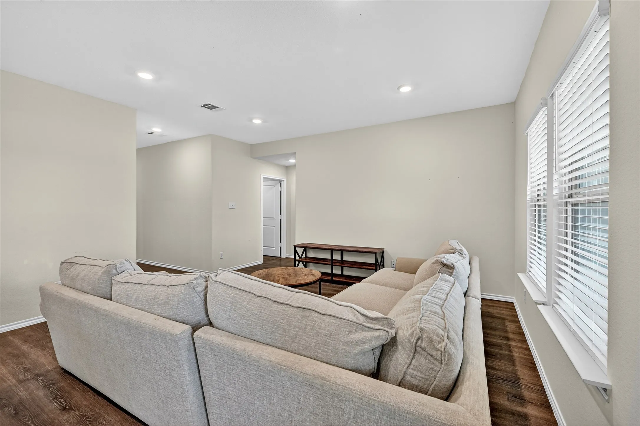 Living room featuring dark wood-type flooring and recessed lighting