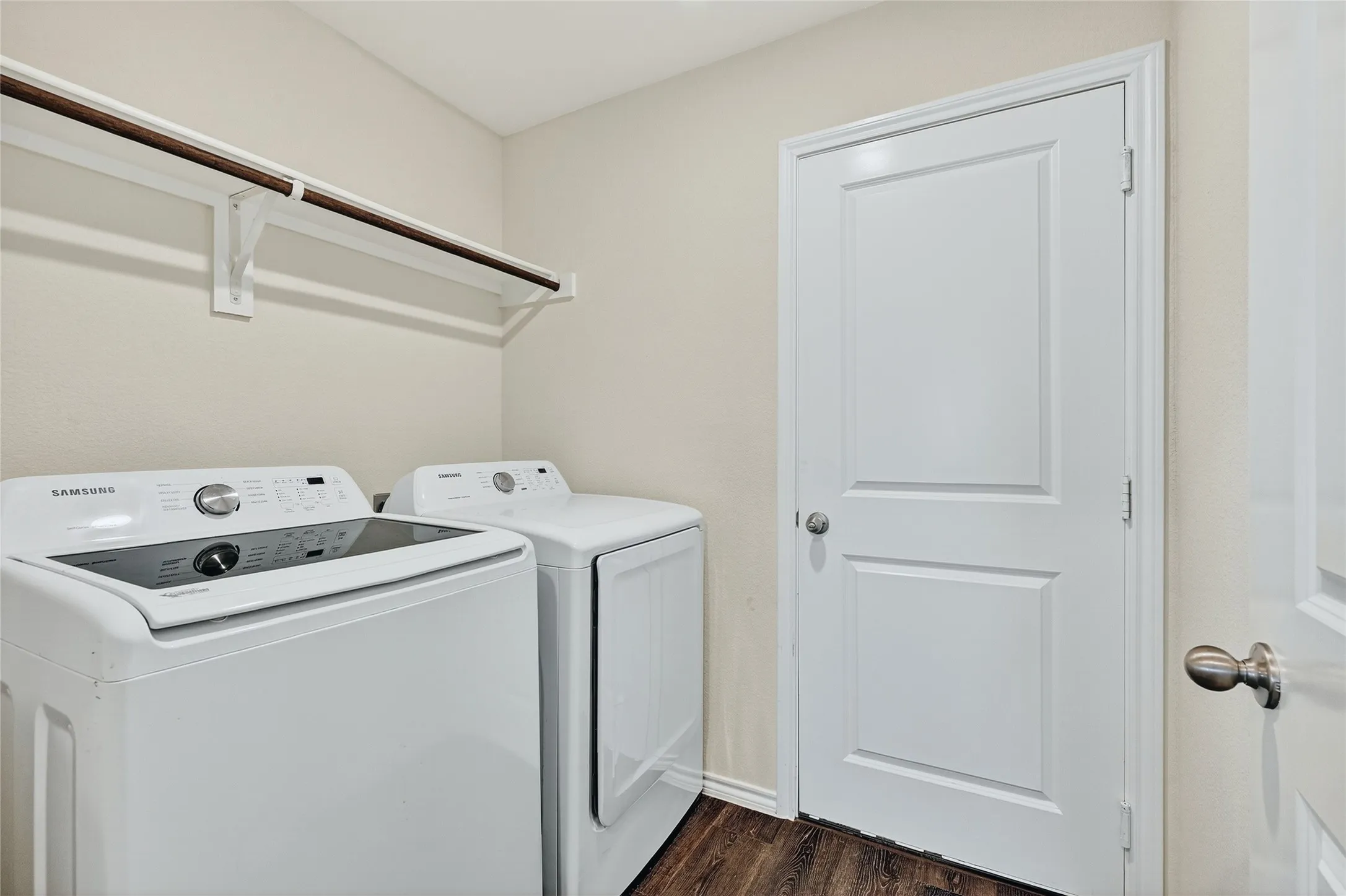Laundry area featuring washing machine and dryer and dark wood-style floors