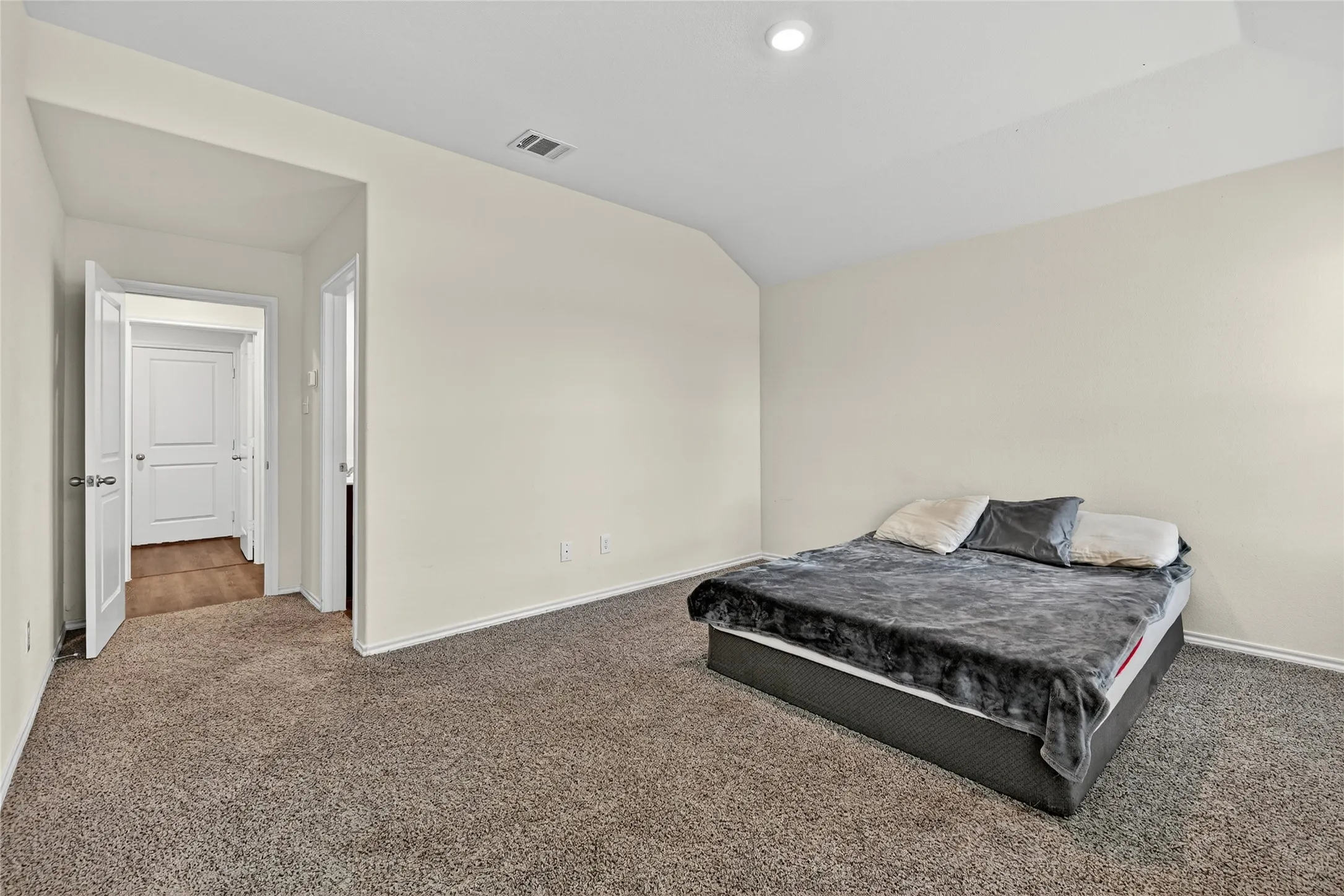 Carpeted bedroom featuring lofted ceiling and recessed lighting