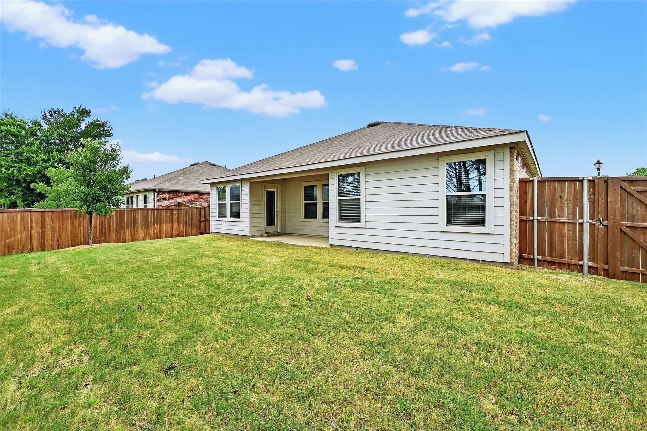 Rear view of property featuring a fenced backyard and a patio area
