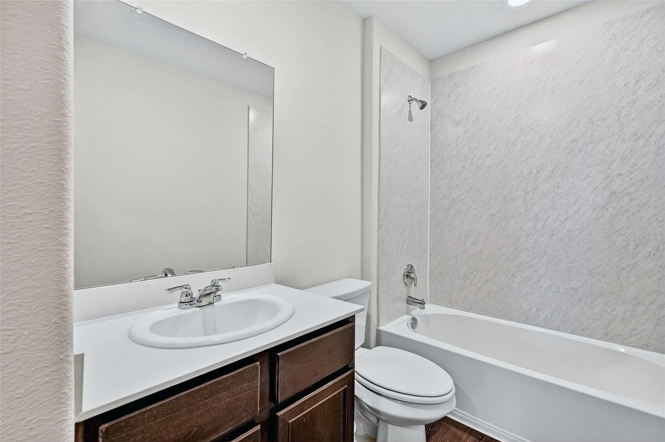 Full bath featuring vanity,  shower combination, and wood finished floors