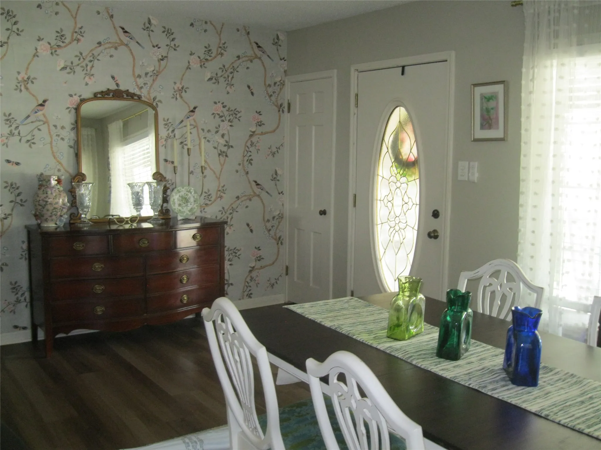 Dining room featuring wood finished floors and wallpapered walls