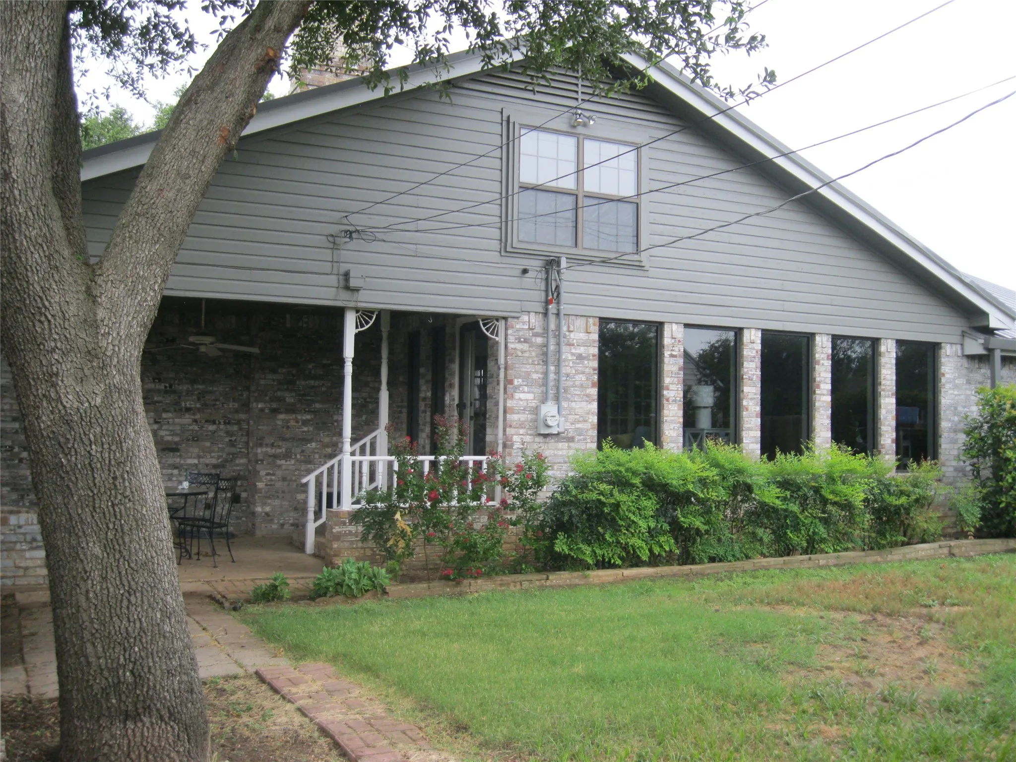 Rear view of property with brick siding and a​​‌​​​​‌​​‌‌​‌‌​​​‌‌​‌​‌​‌​​​‌​​ yard