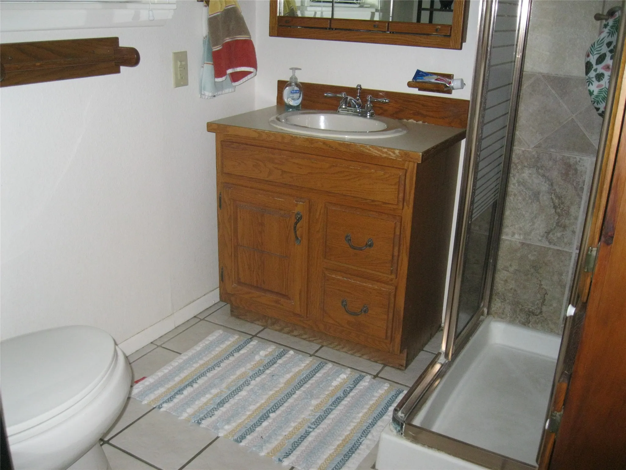 Bathroom with a shower stall, vanity, and tile patterned floors