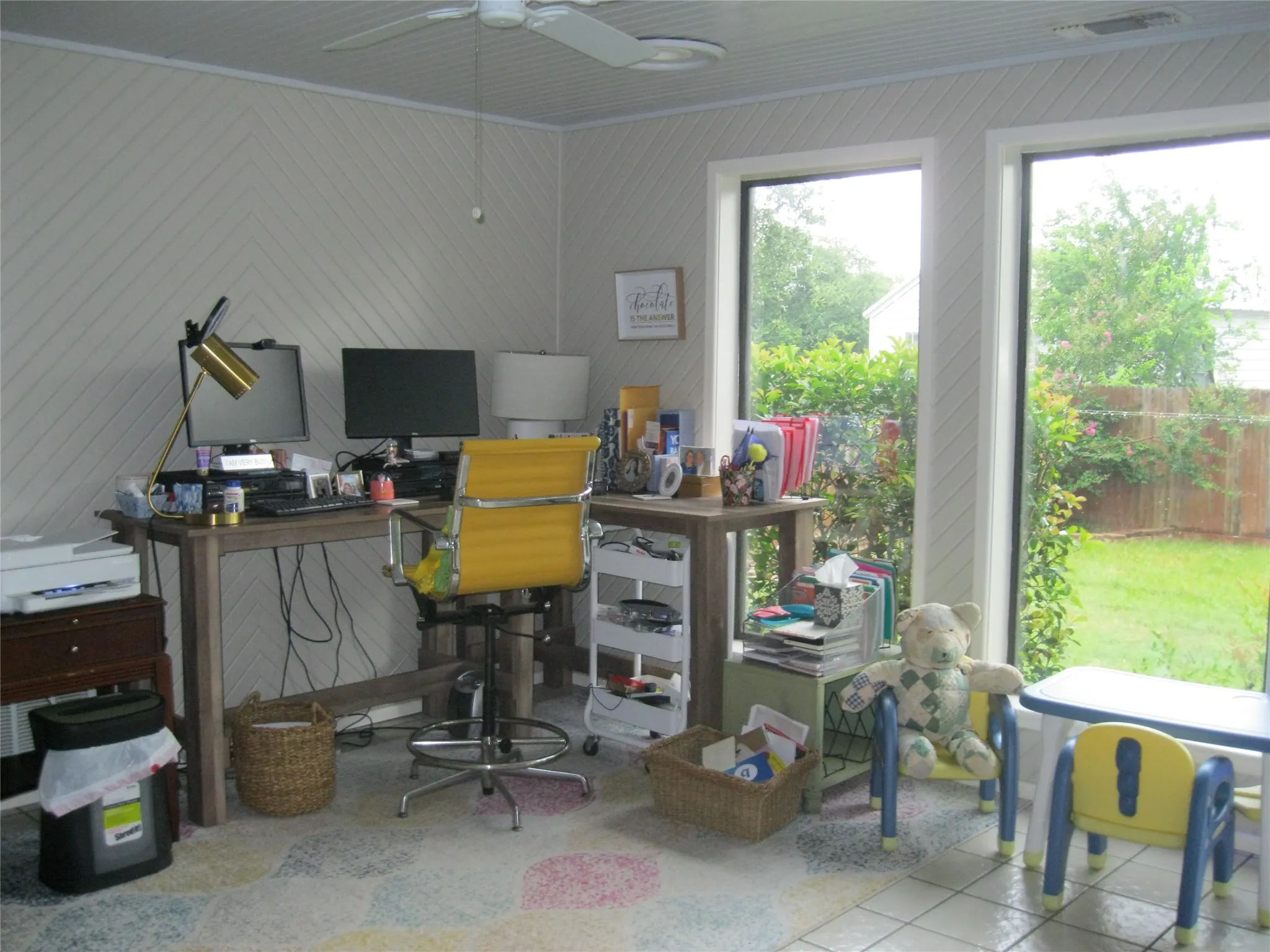Office space with a ceiling fan and tile patterned flooring
