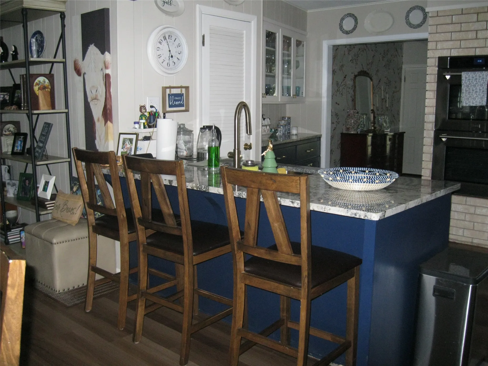 Kitchen featuring glass insert cabinets, wood finished floors, and a breakfast bar