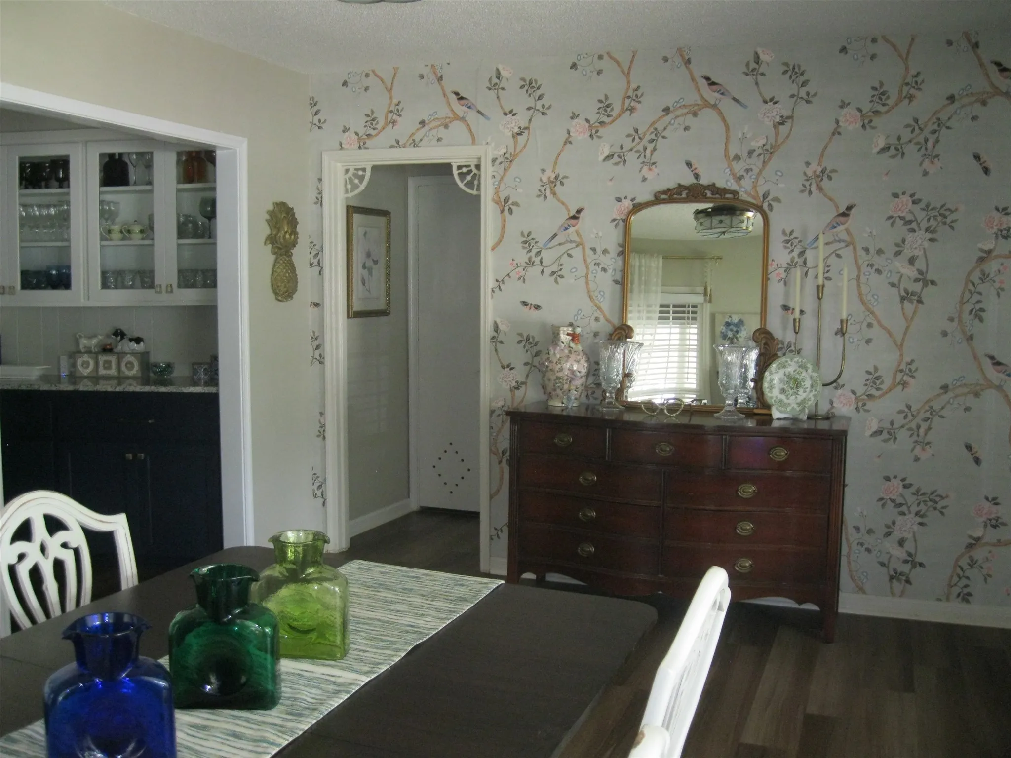 Dining room with wallpapered walls and wood finished floors