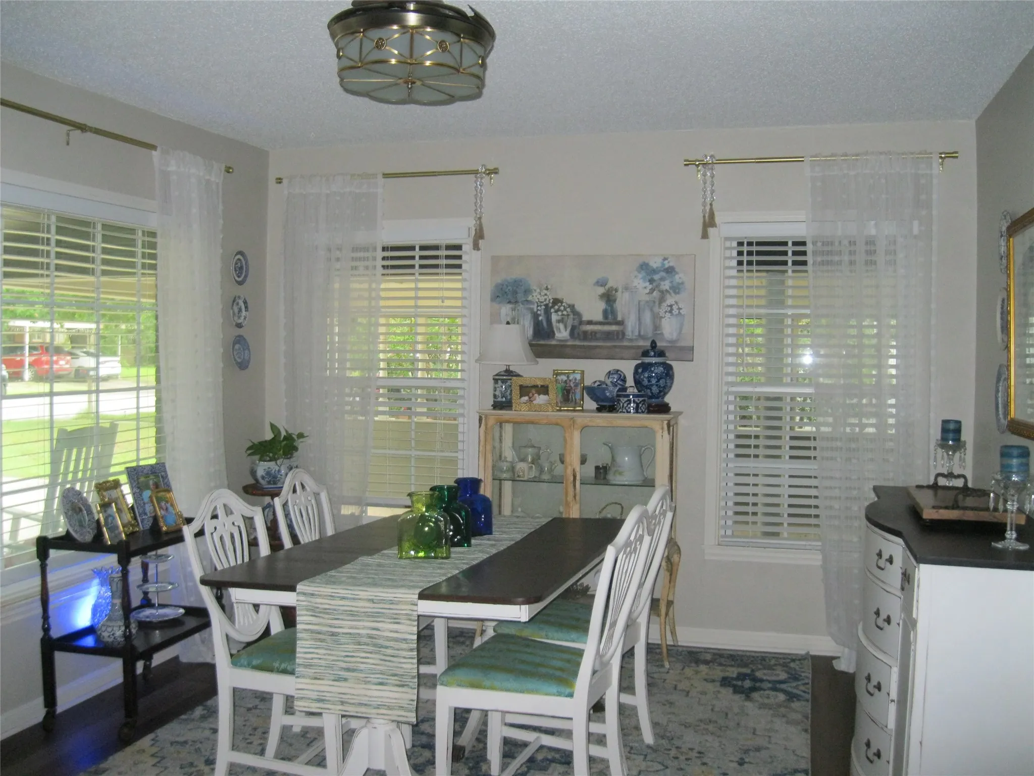 Dining space featuring healthy amount of natural light, a chandelier, a textured ceiling, and wood finished floors