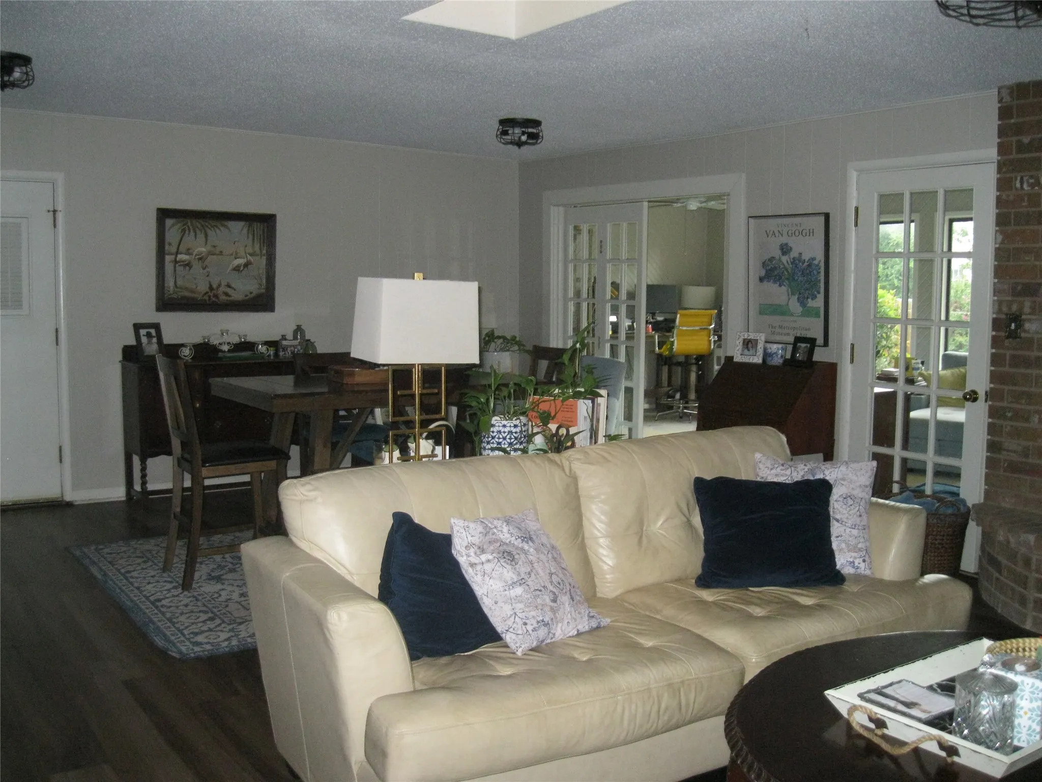Living area with wood finished floors, a textured ceiling, and french doors