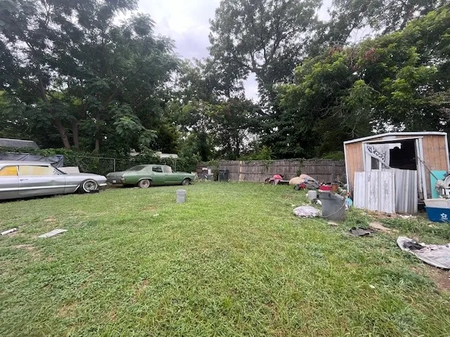 View of yard with a storage shed and view of wooded area