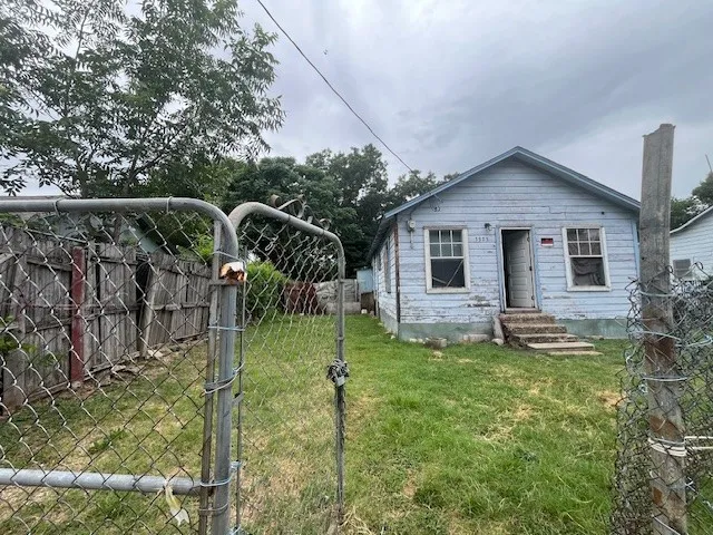 View of front facade with entry steps and a gate