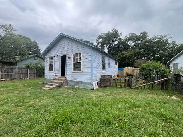 Back of property with entry steps and a fenced backyard