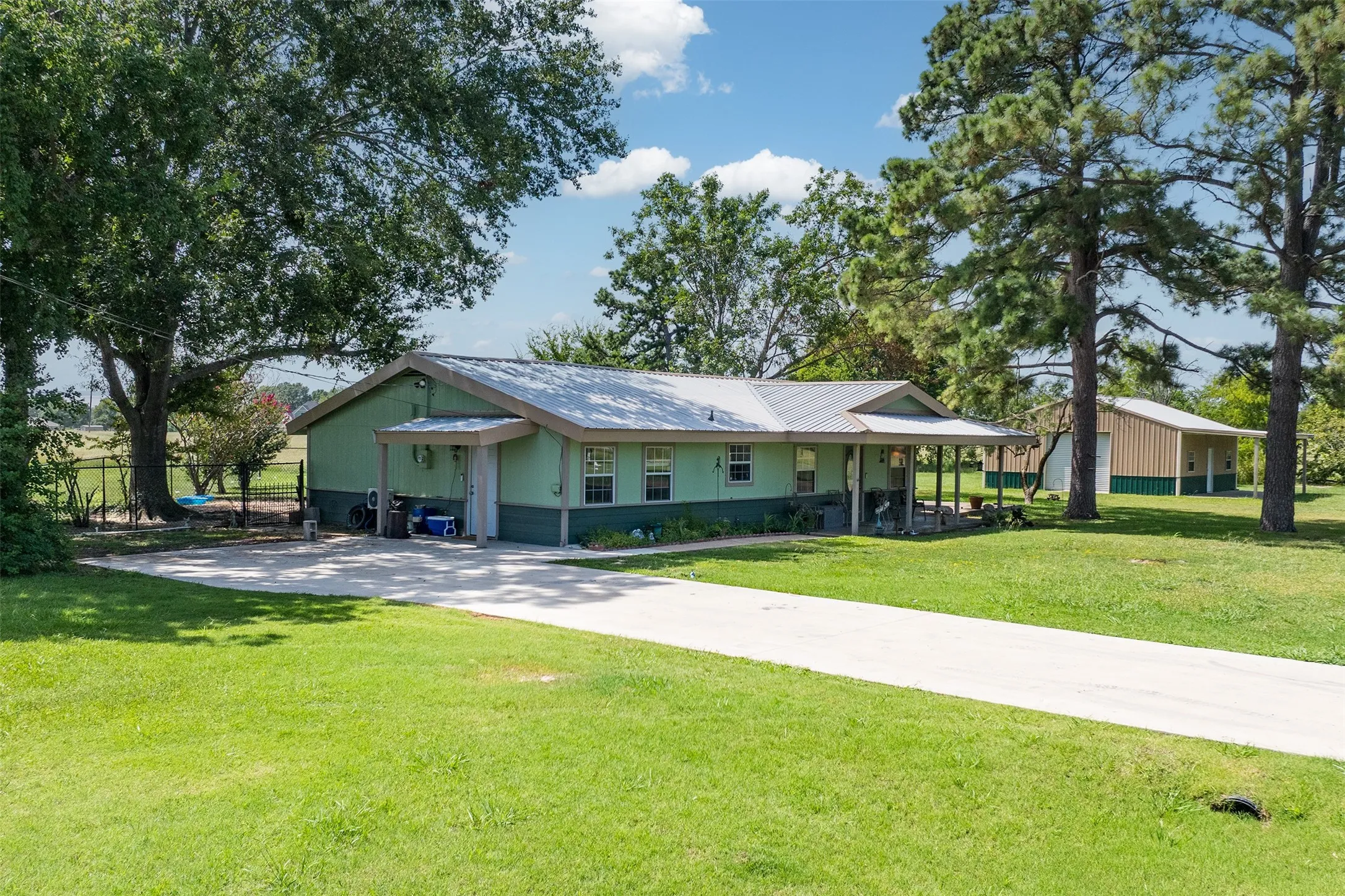 View of front of home featuring driveway and a metal roof