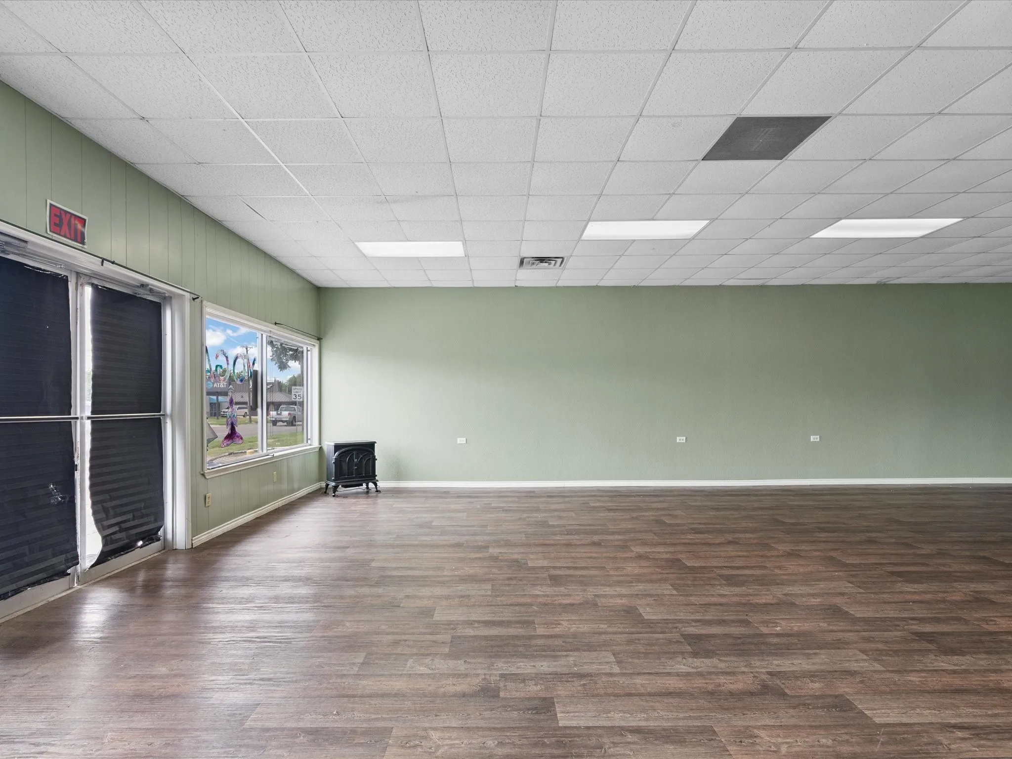 Unfurnished room featuring wood finished floors and a wood stove