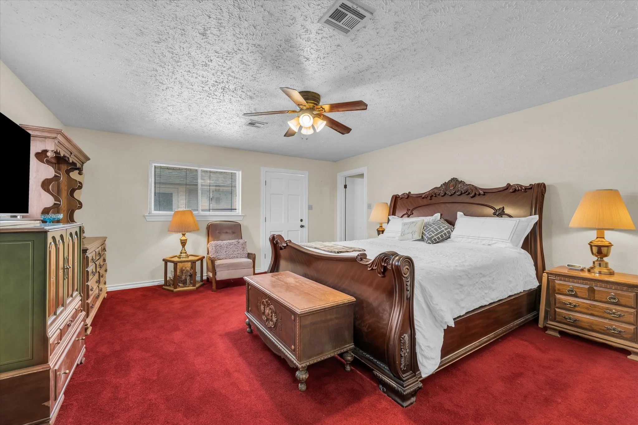 Carpeted bedroom with a textured ceiling and a ceiling fan