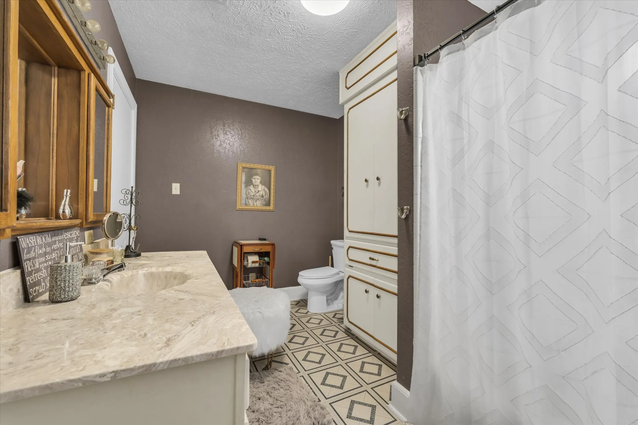 Bathroom with vanity, a textured ceiling, and a shower with shower curtain