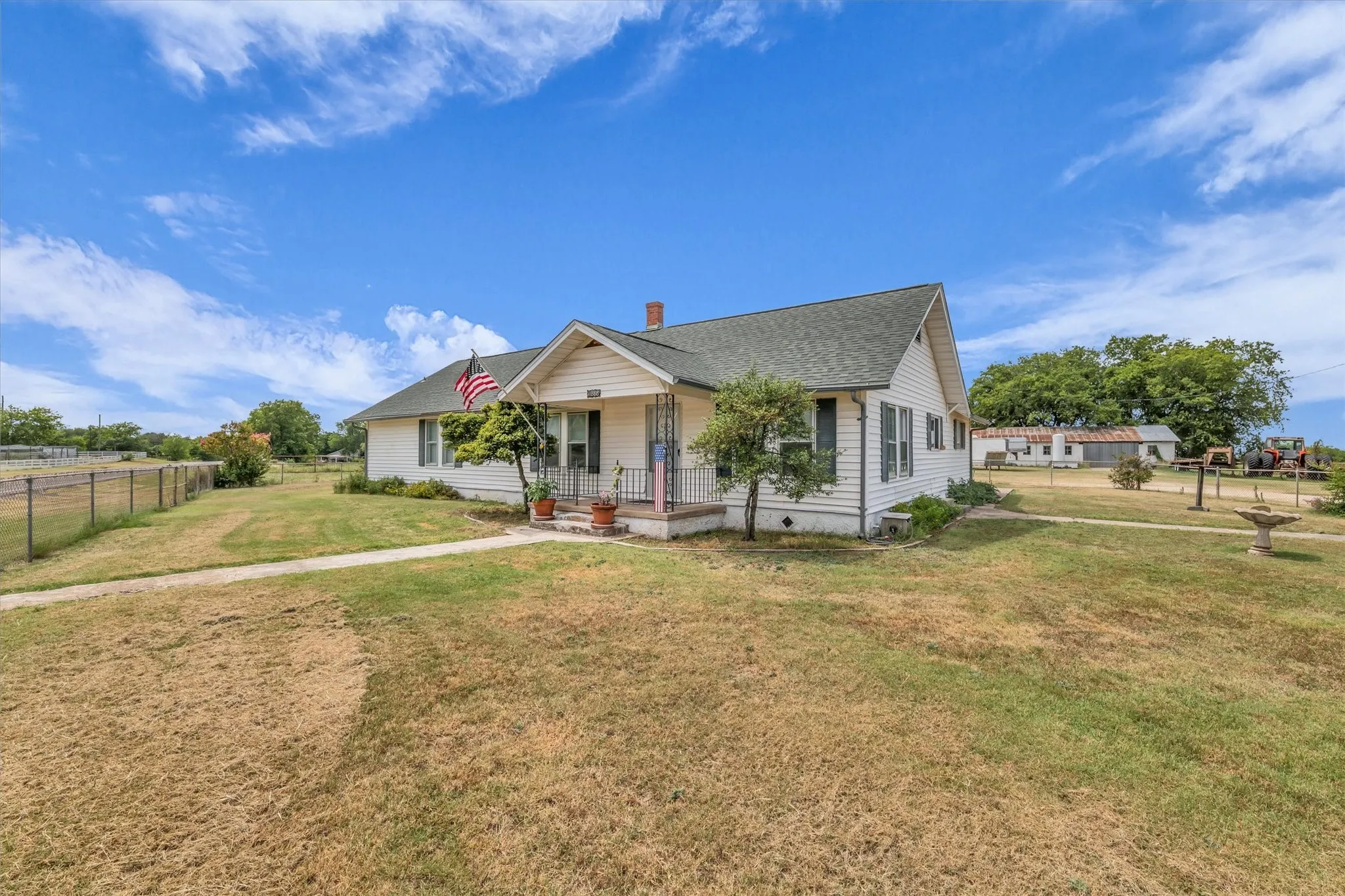 View of front of house featuring a porch, a shingled roof, and a chimney