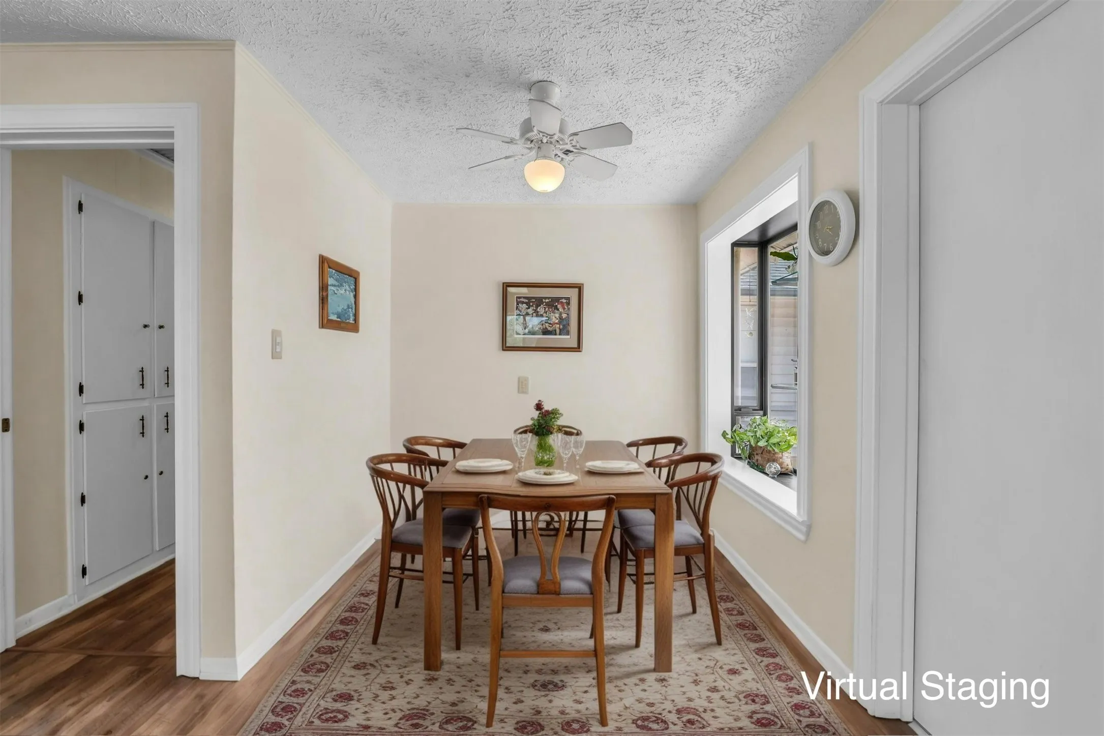 Dining room with wood finished floors, a ceiling fan, and a textured ceiling