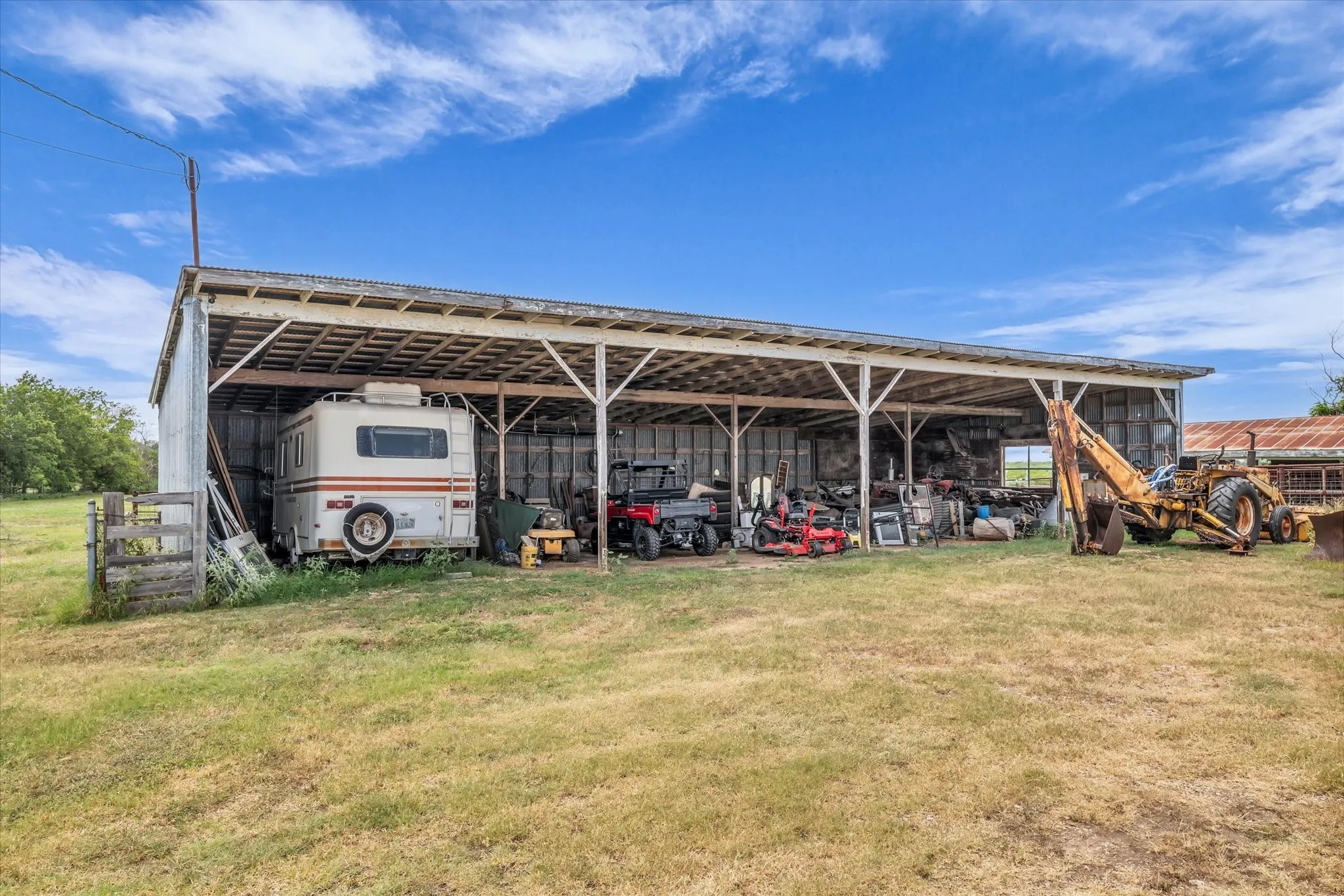 View of pole building with a carport and a lawn