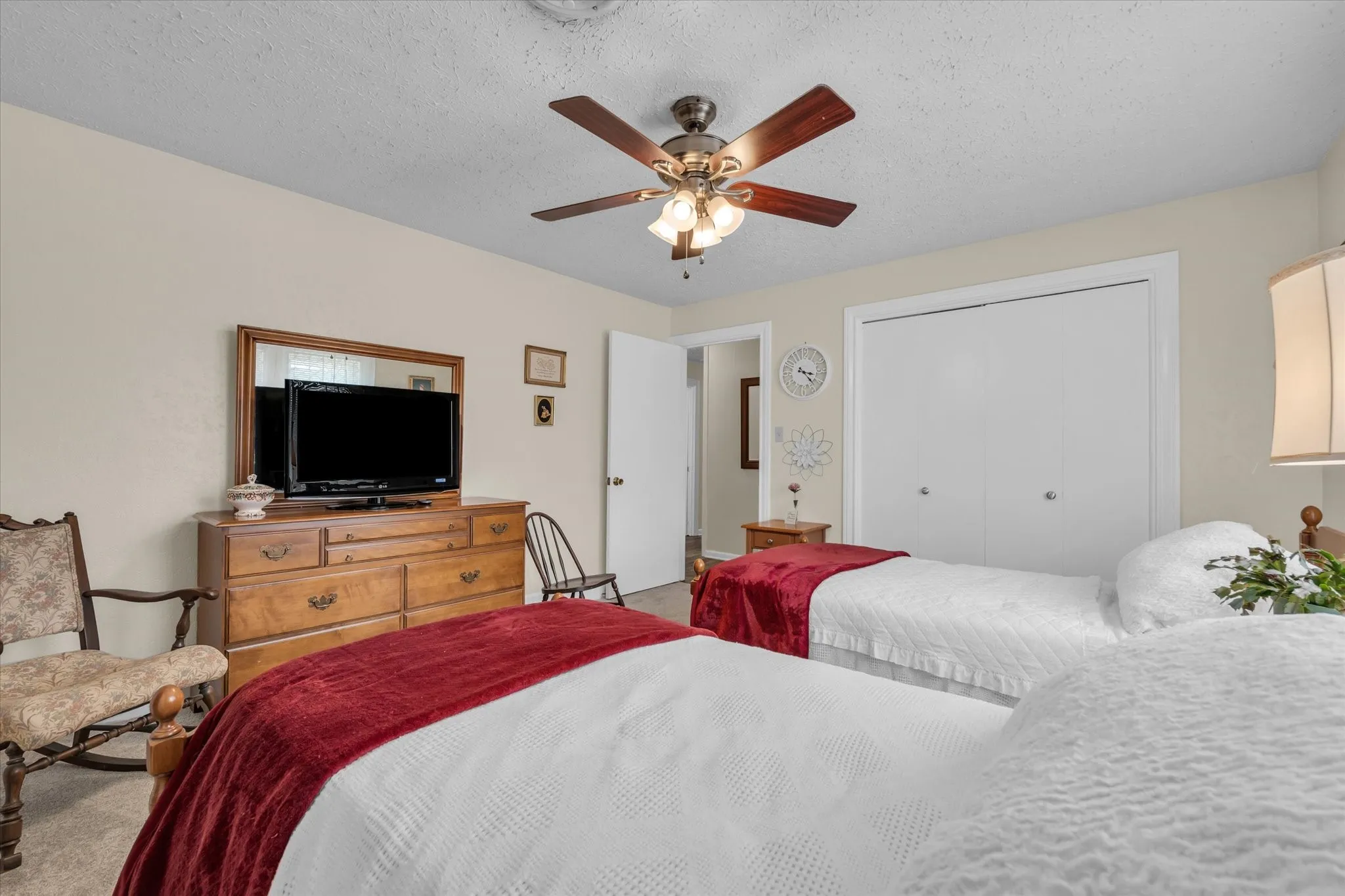 Carpeted bedroom featuring a ceiling fan and a closet