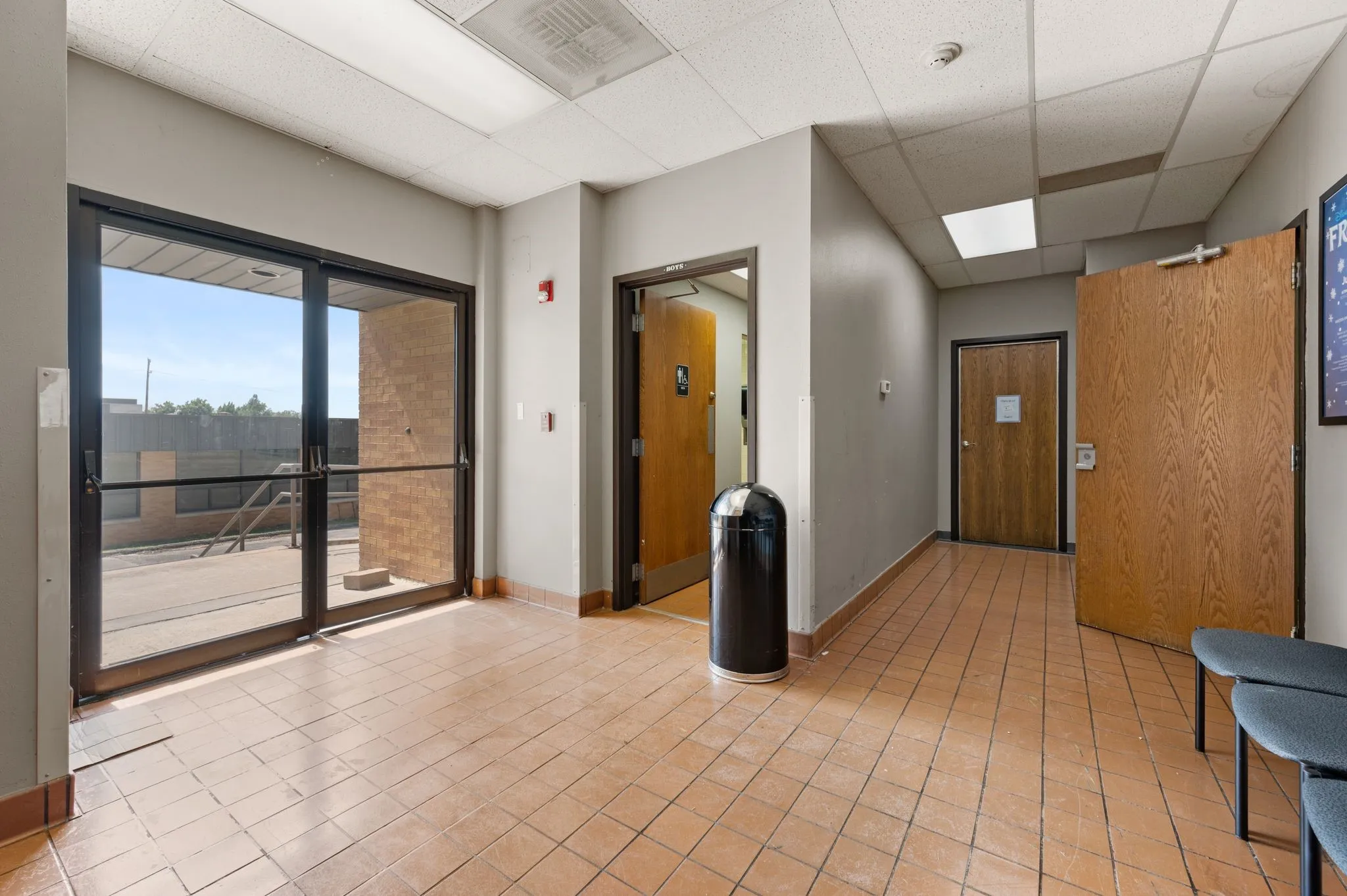 Unfurnished room with a drop ceiling, a smoke detector, and light tile patterned flooring