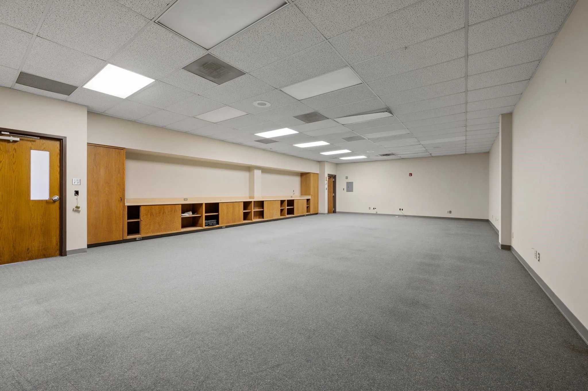 Unfurnished room featuring carpet flooring and a drop ceiling