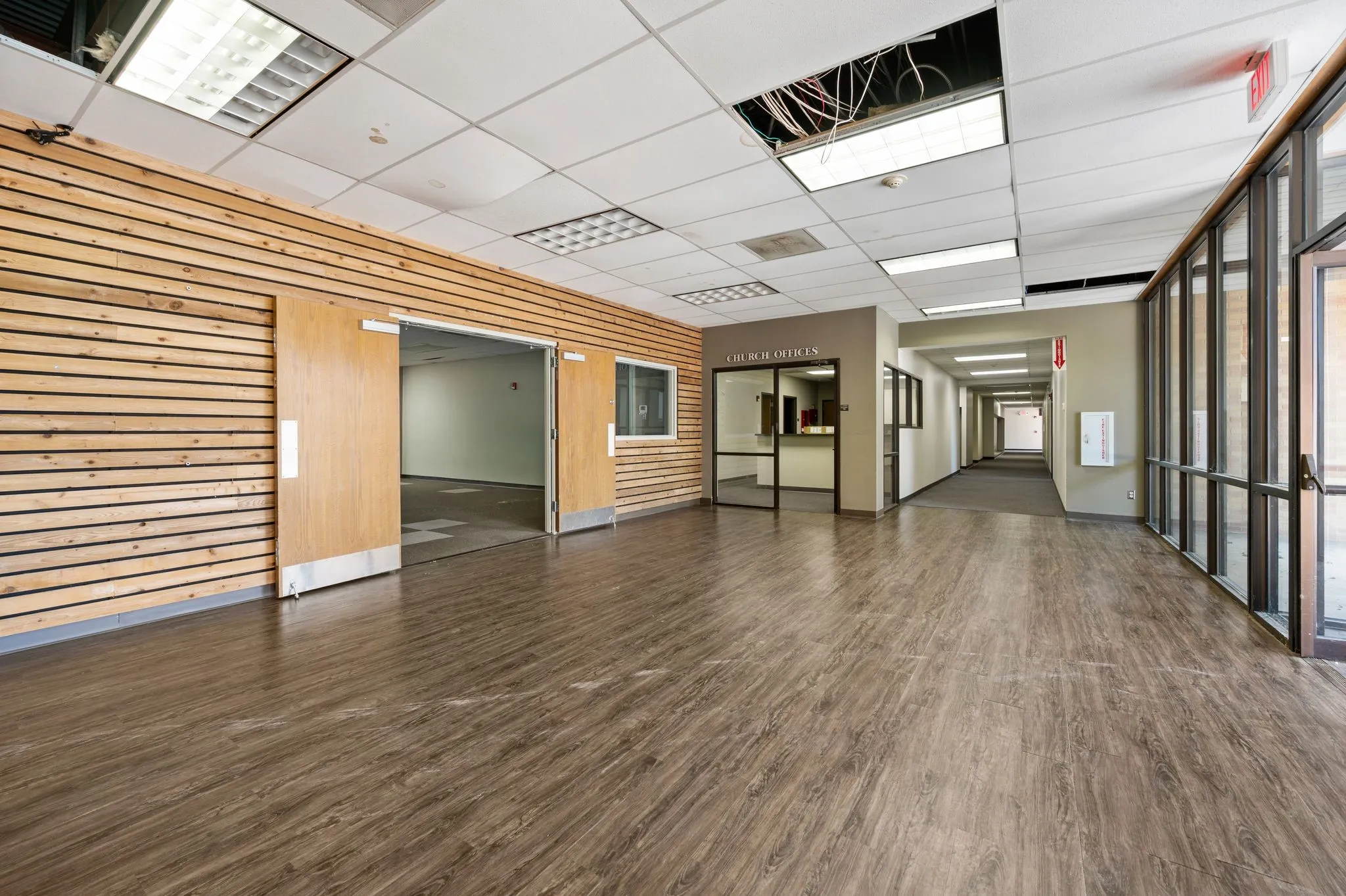Unfurnished room with wooden walls, dark wood-style floors, and a paneled ceiling