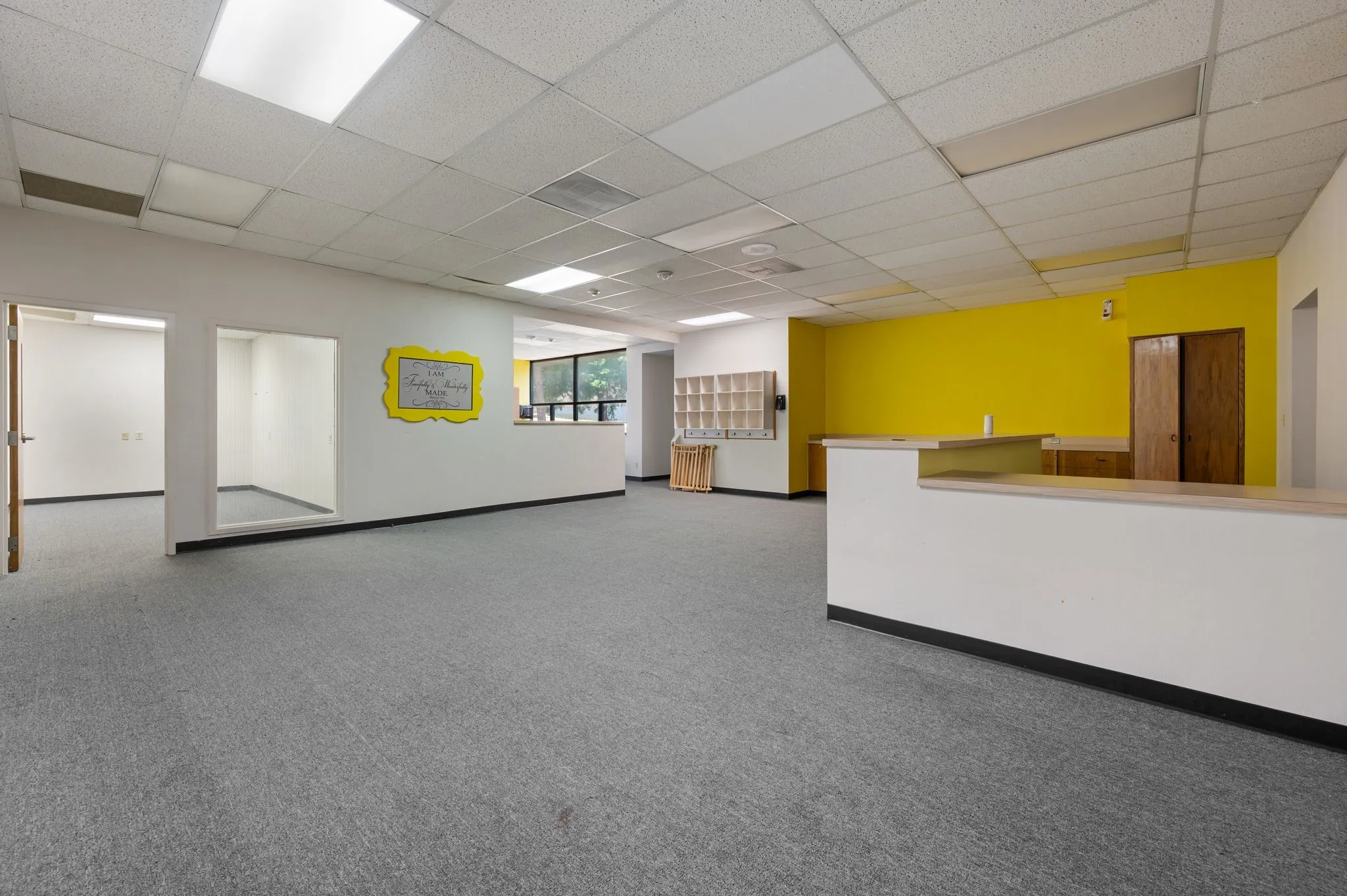 Spare room featuring a drop ceiling, carpet flooring, and wet bar