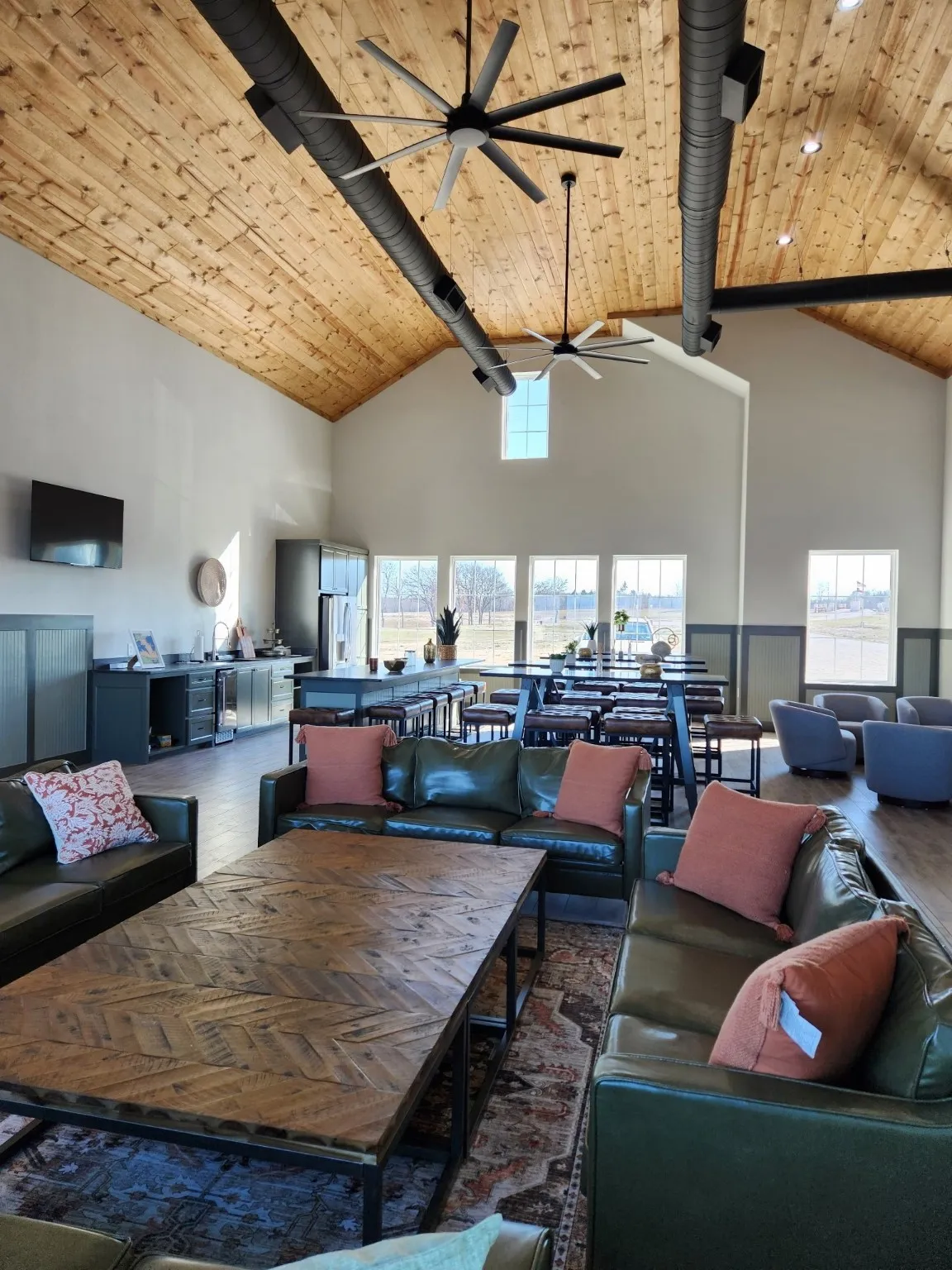 Living room featuring high vaulted ceiling, wood ceiling, and a ceiling fan
