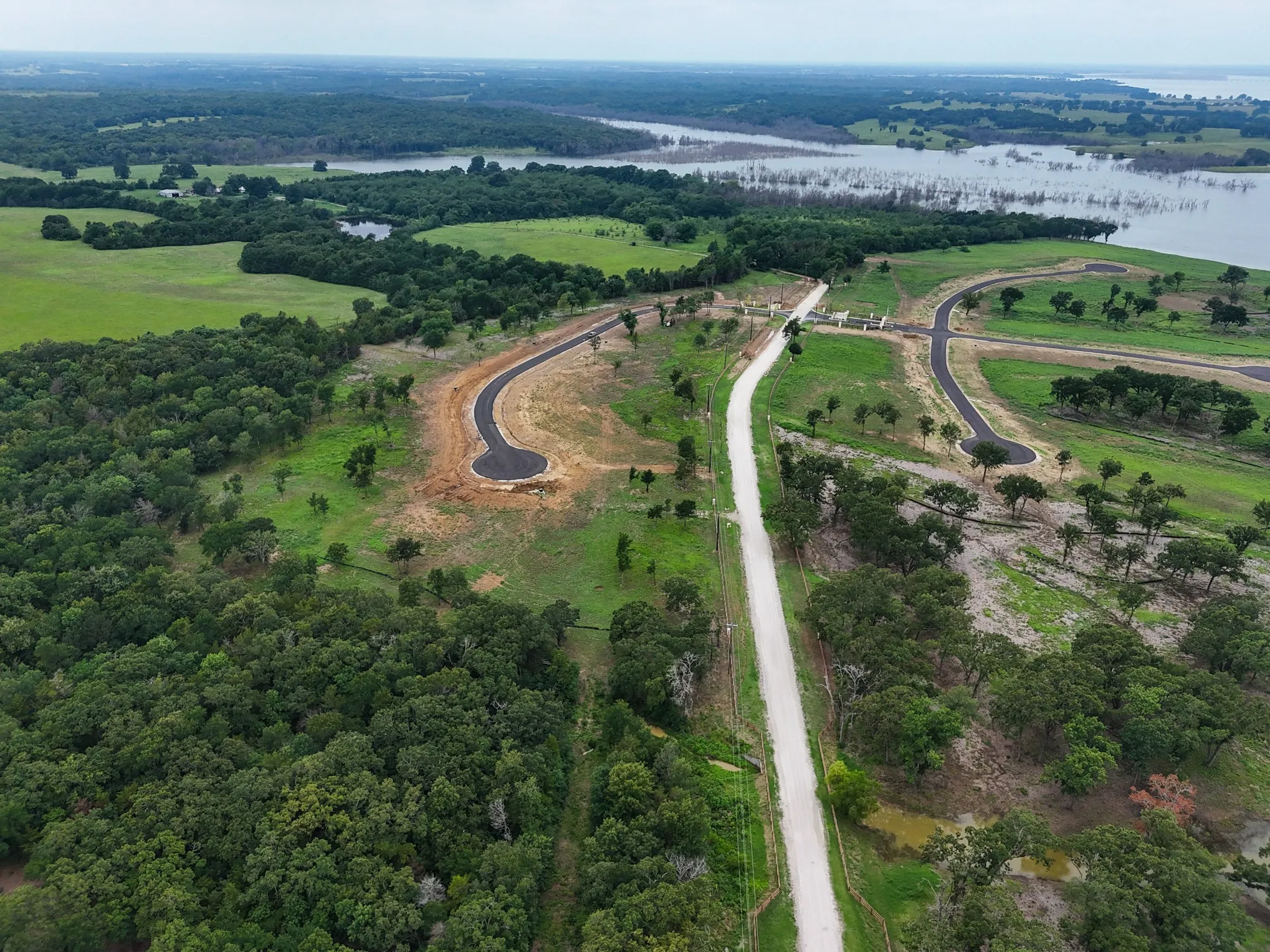 Aerial view of property and surrounding area with a nearby body of water