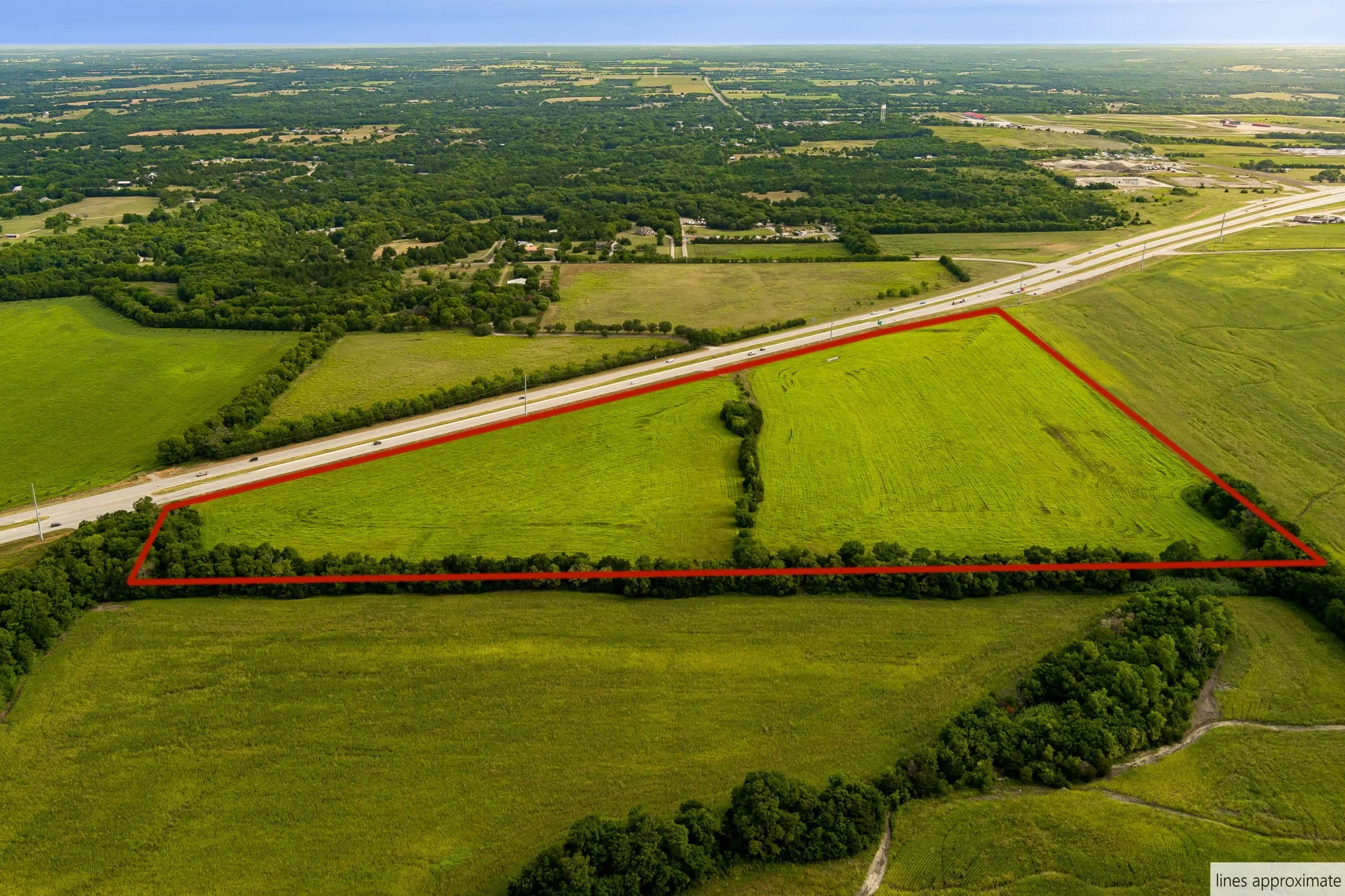 Aerial view of sparsely populated area featuring property parcel outlined