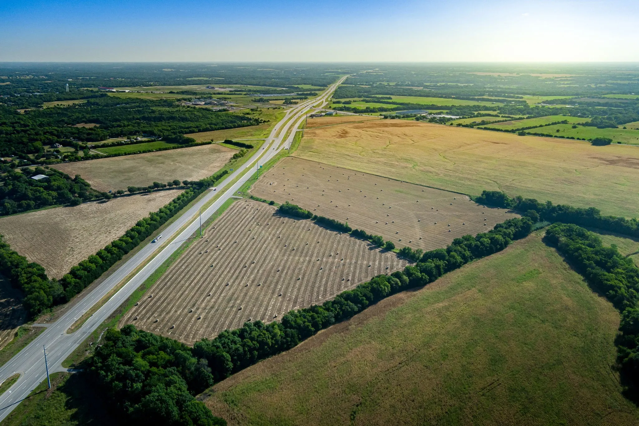 Aerial view of property and surrounding area featuring rural landscape and extensive farmland