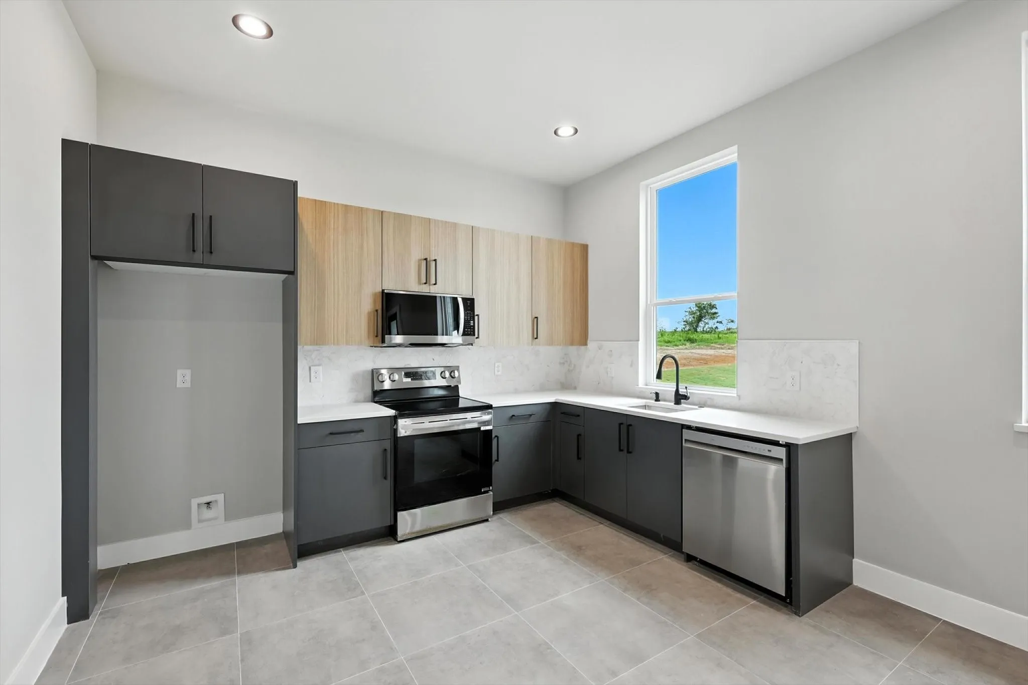 Kitchen with stainless steel appliances, decorative backsplash, light countertops, recessed lighting, and light tile patterned floors