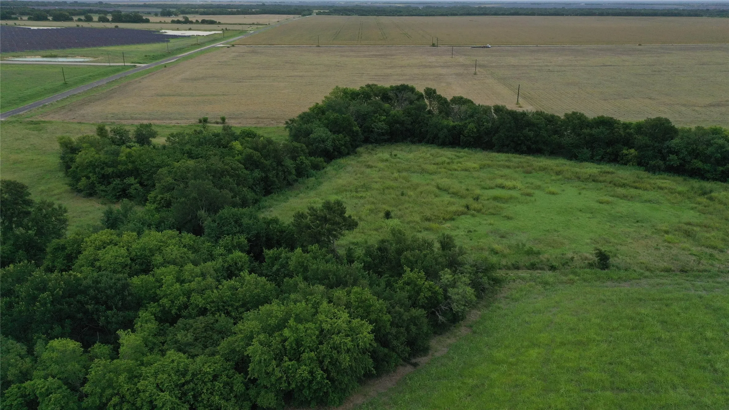 Aerial view of property and surrounding area featuring rural landscape and farmland