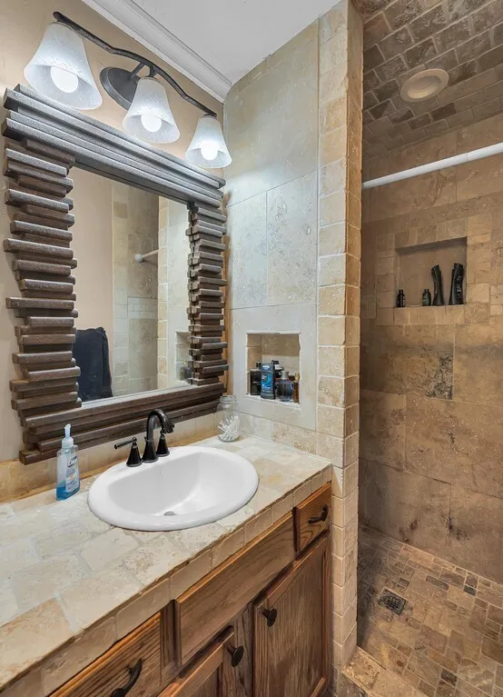 Full bath with a tile shower and vanity