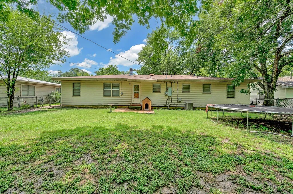 Rear view of property featuring a trampoline