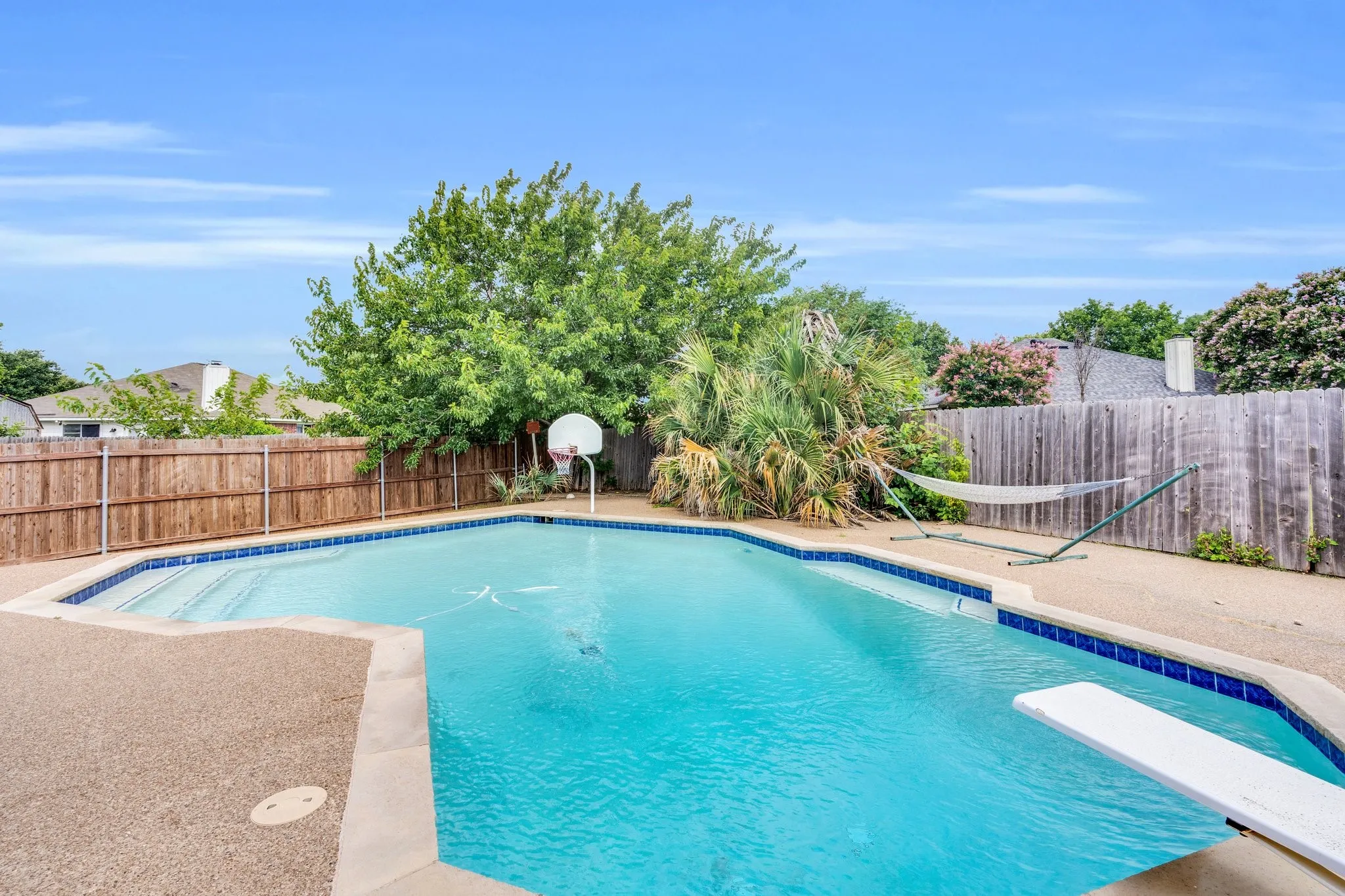 View of pool featuring a fenced backyard and a diving board