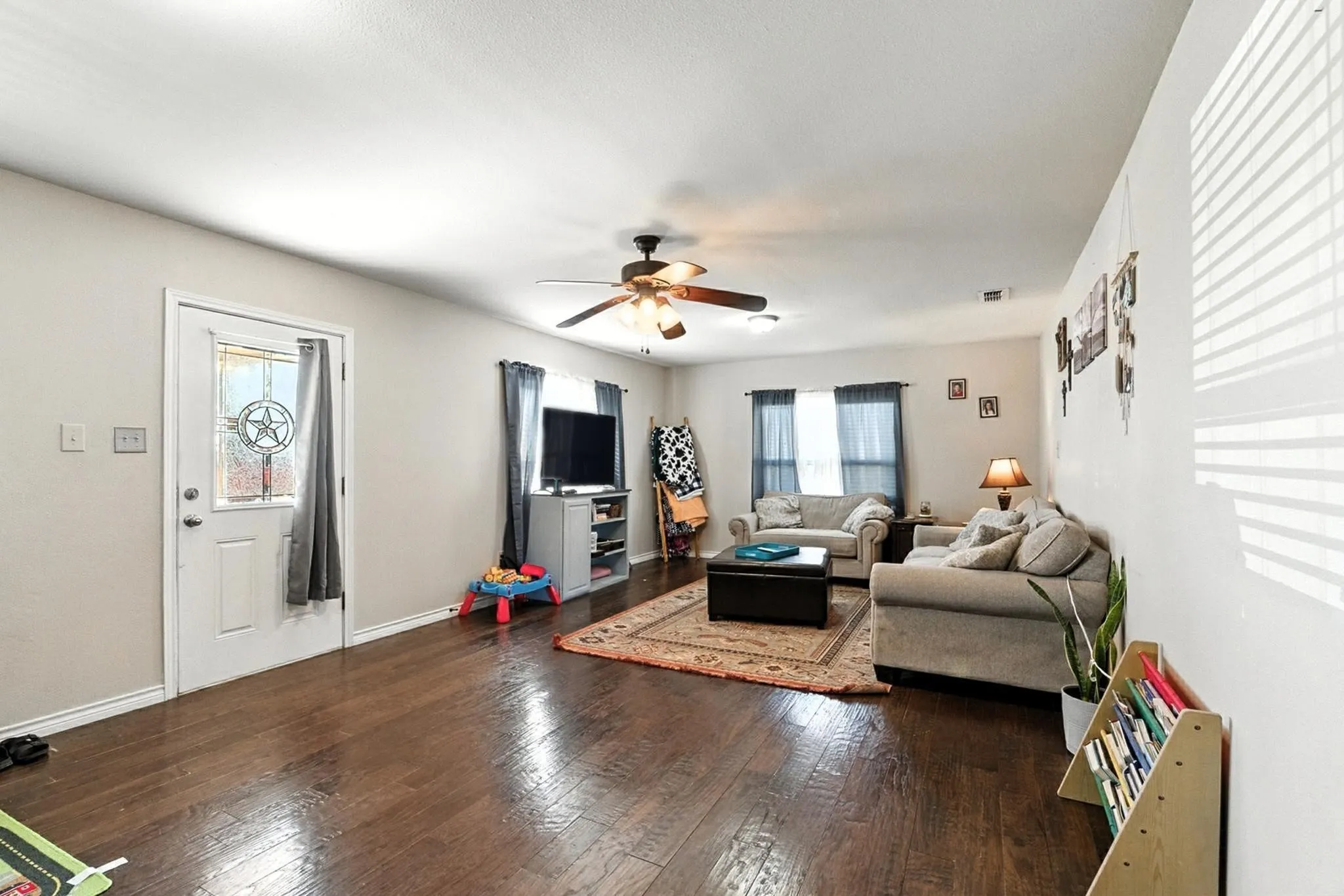 Living room featuring a ceiling fan and hardwood / wood-style flooring