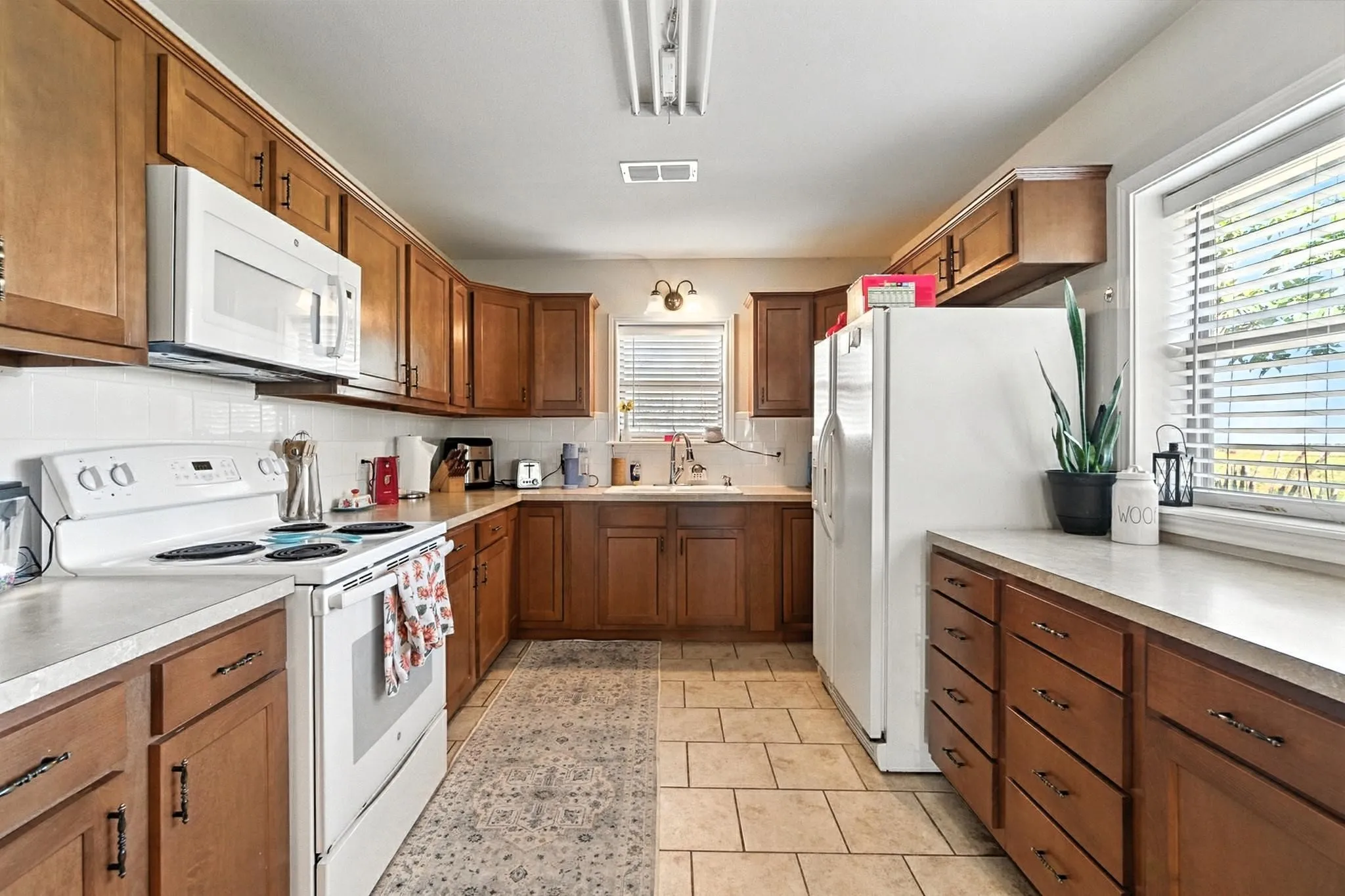 Kitchen with white appliances and brown cabinetry